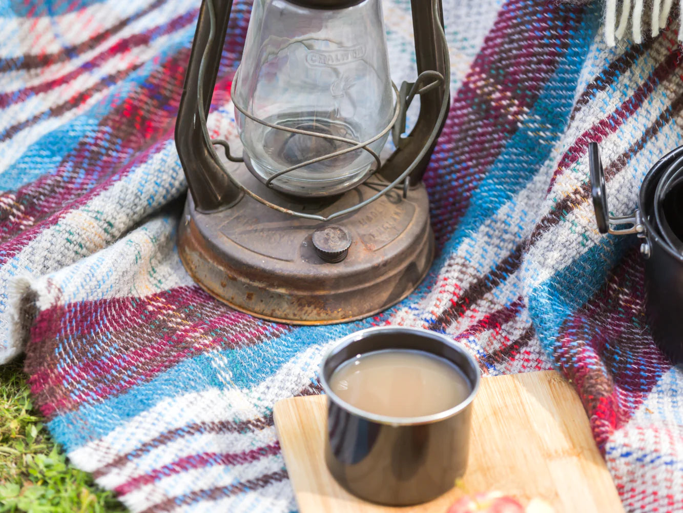 A kerosene lamp and a mug of coffee sit on a table, evoking a cozy, rustic setting.