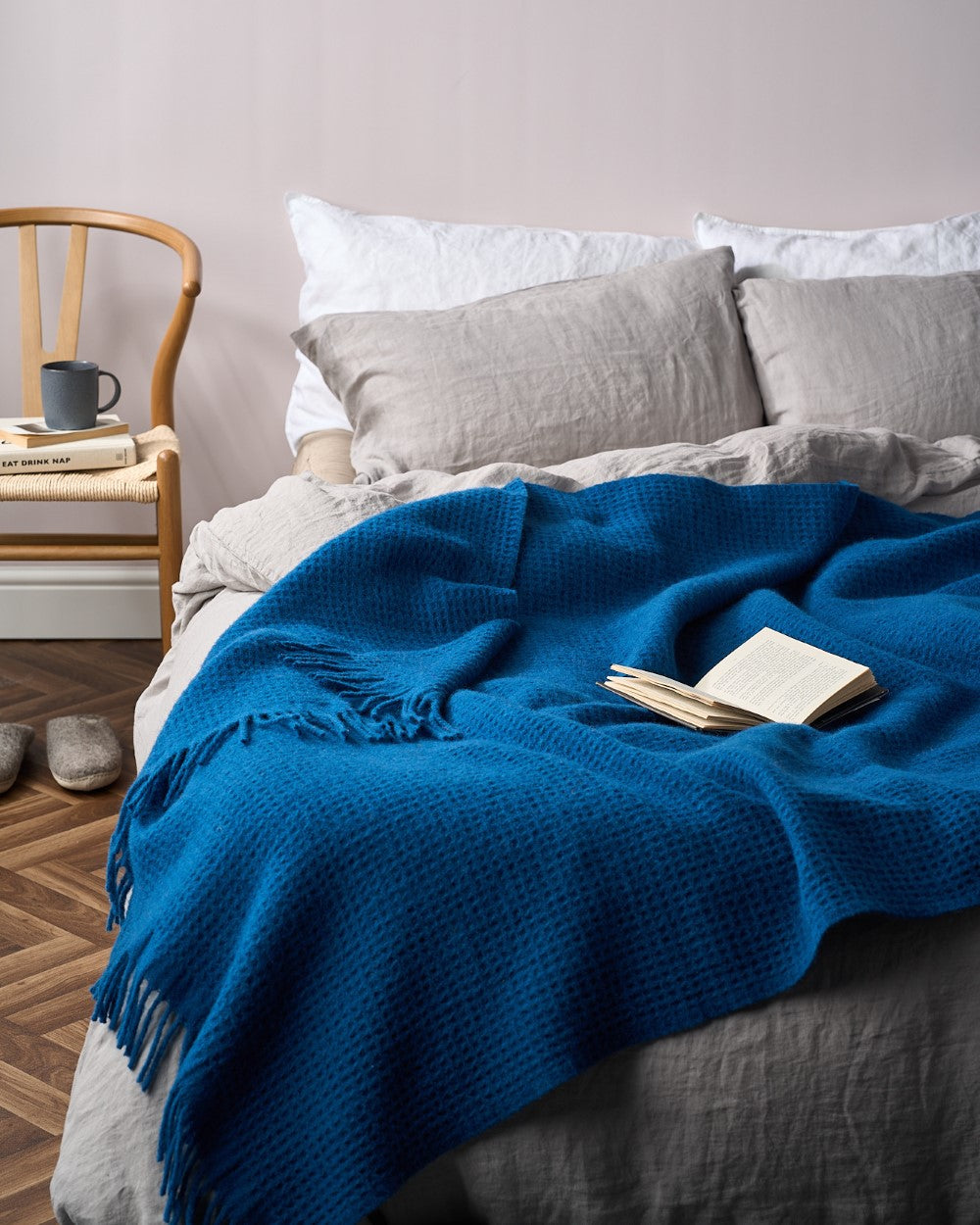 blue wool waffle blanket on bed with book