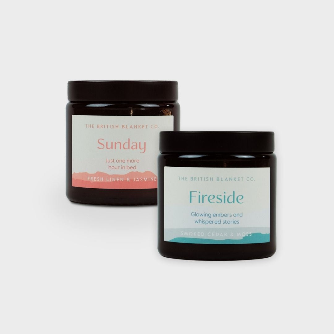 Bright Friday Blanket Bundle: Lido features two amber-glass jar candles labeled Sunday and Fireside, highlighting fresh linen, jasmine, smoked cedar, and moss scents.