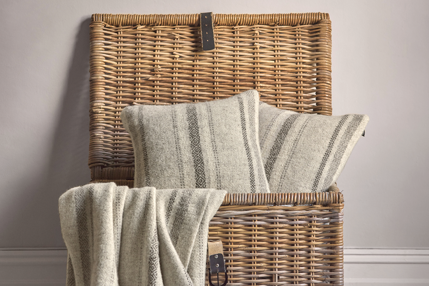 Floor basket with British Wool cushions and blankets spilling out from the british blanket company