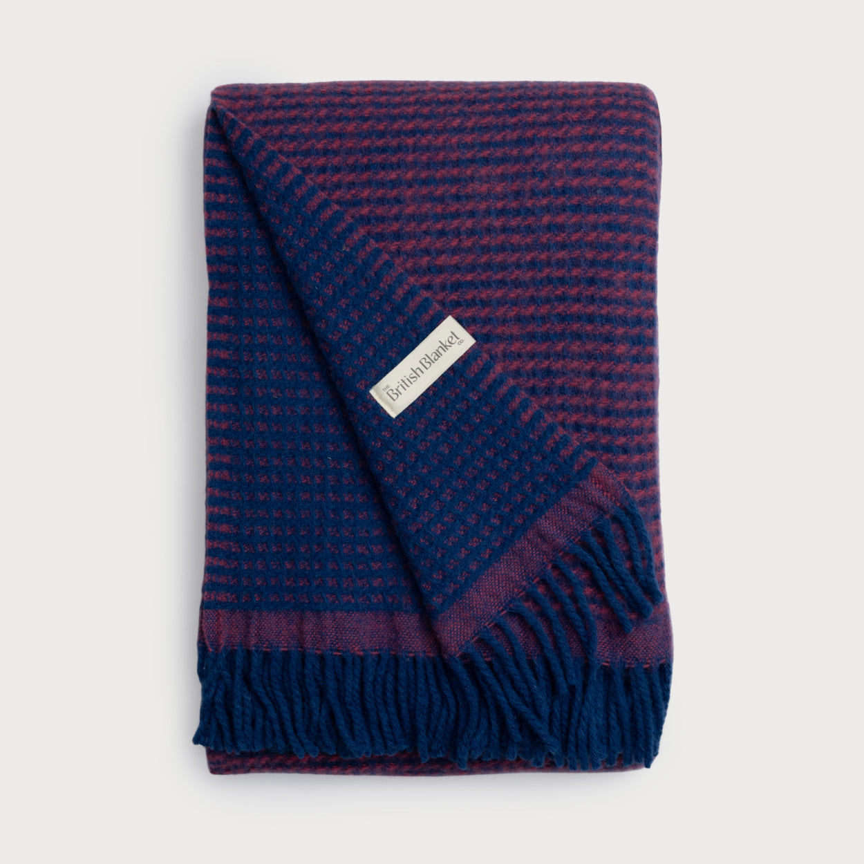 Totterdown Waffle Blanket: Curious & Lush, in a vibrant dual-color, featuring a reversible waffle weave and a white label, made from pure sheep's wool.