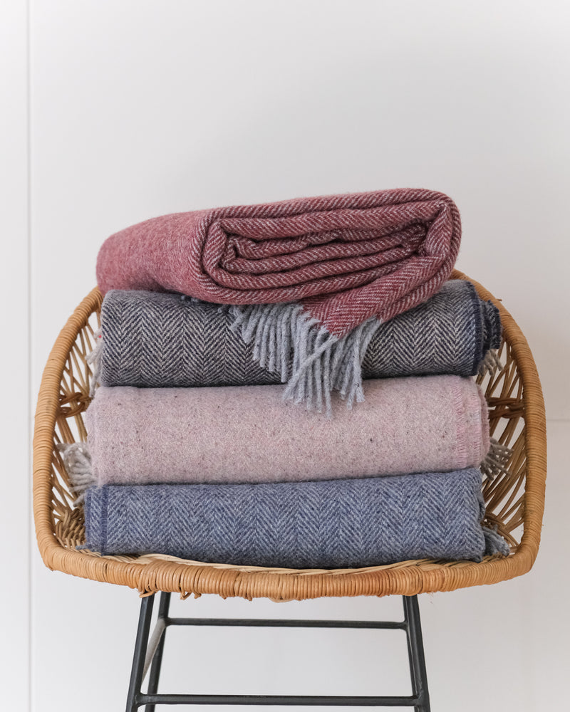 Stack of Cashmere and Merino Recycled Wool Blankets on a chair by Turtle Doves for The British Blanket Company