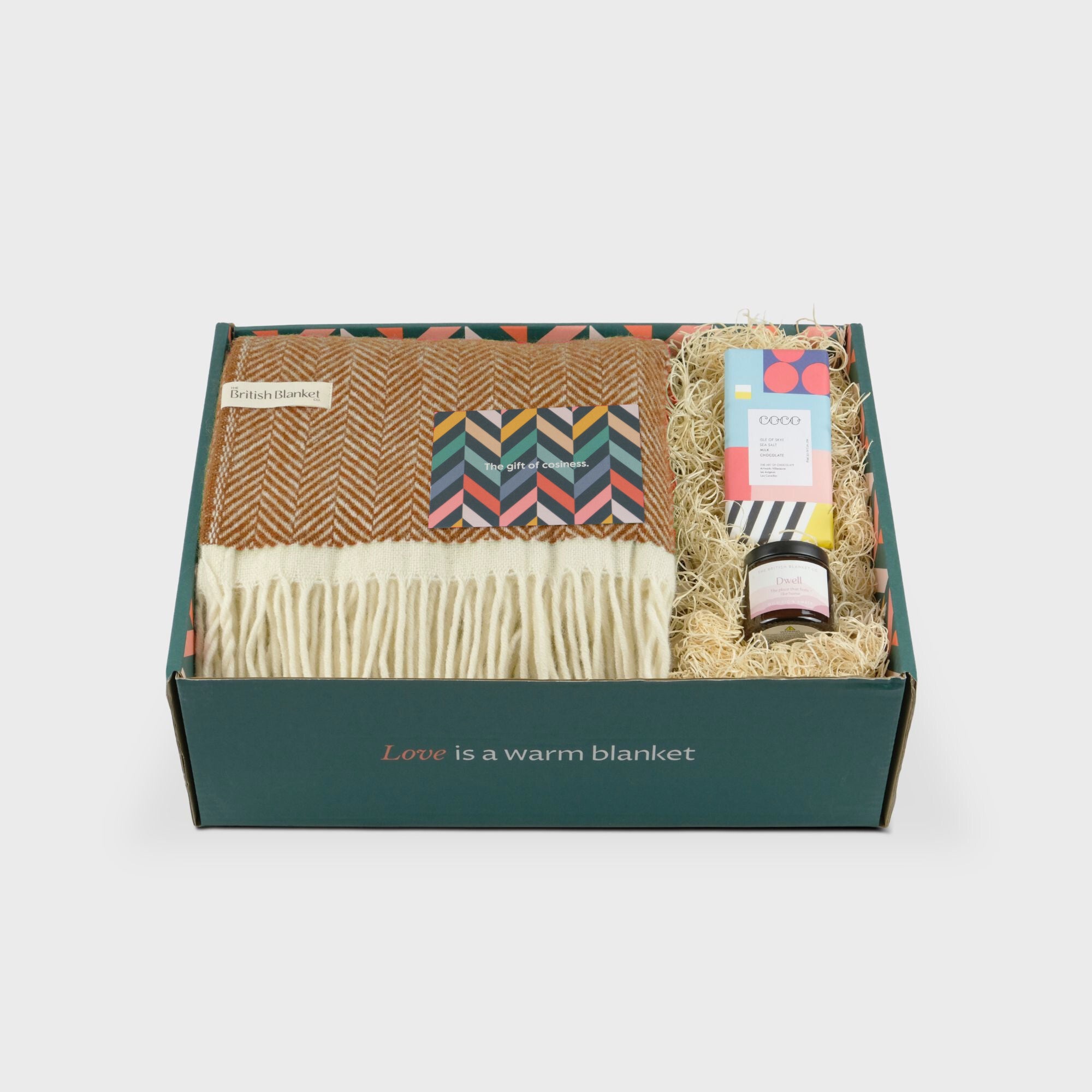 Clifton Blanket Gift Box: Spiced Cider includes a herringbone-patterned throw, greeting card, wrapped chocolate bar, and a small jar nestled in straw.