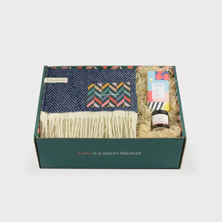 Clifton Blanket Hamper: Brunel features a fringed wool throw, chevron greeting card, specialty bar, and jar, all nestled in shredded paper filling.