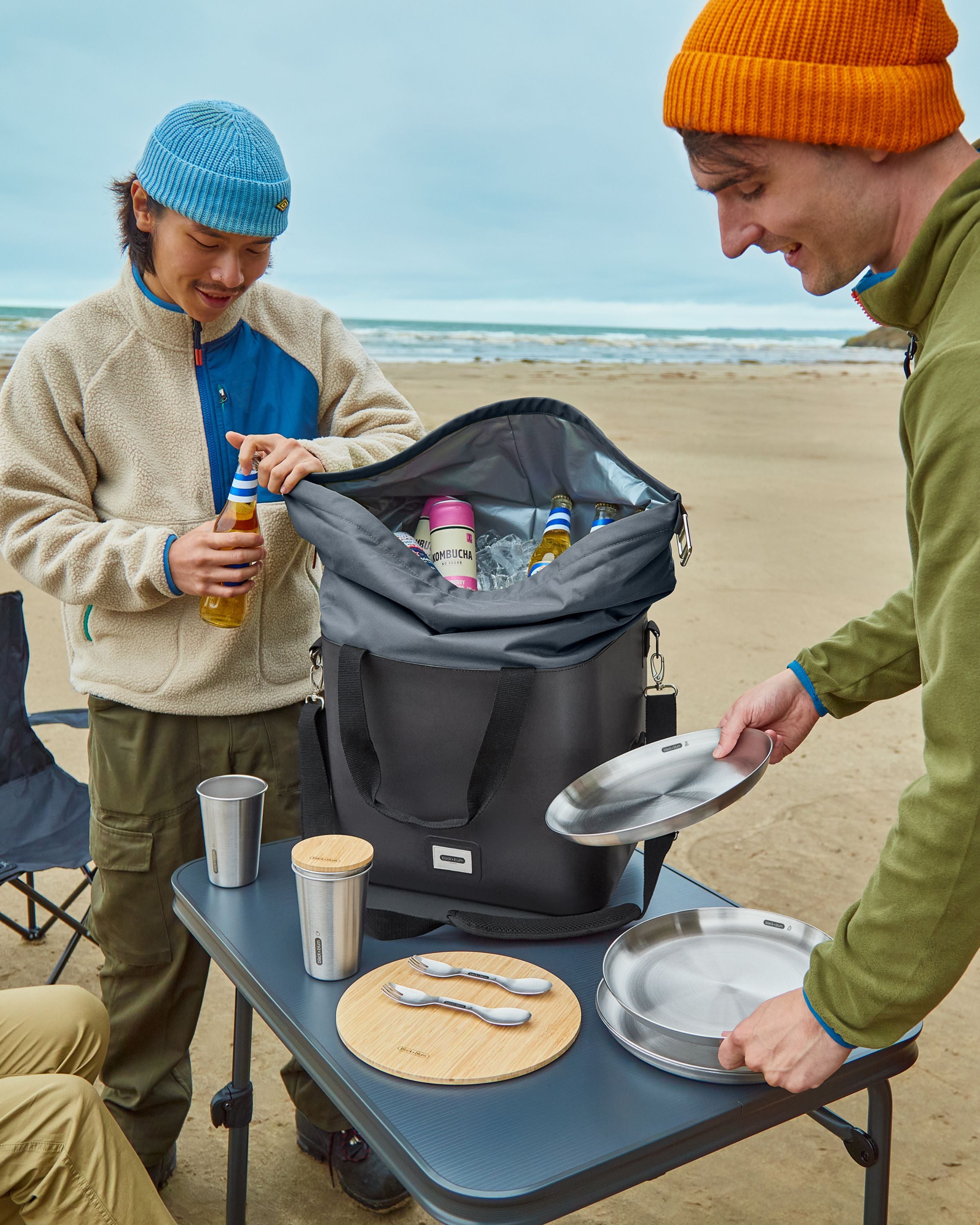 Group of friends preparing lunch with the Black + Blum collection on the beach