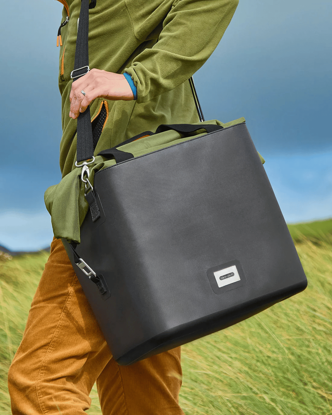 Person walking with the Black + Blum Moss Green Cooler bag