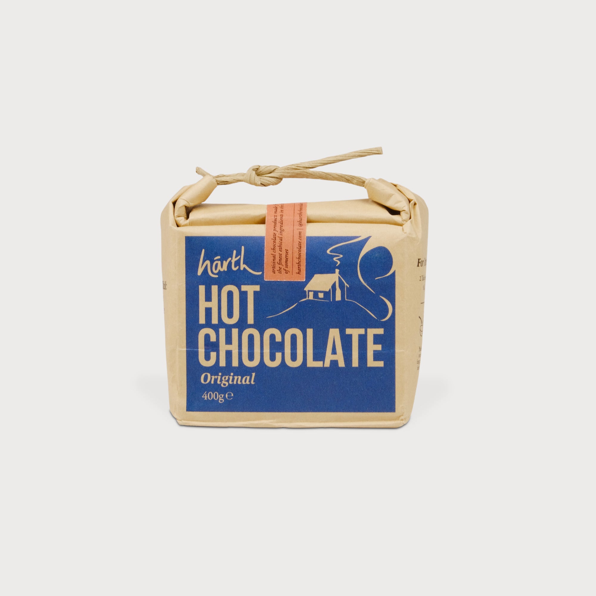 Artisan Ginger Hot Chocolate 400g block, wrapped in brown paper with a blue label, tied with twine. Mix with milk for velvety indulgence.
