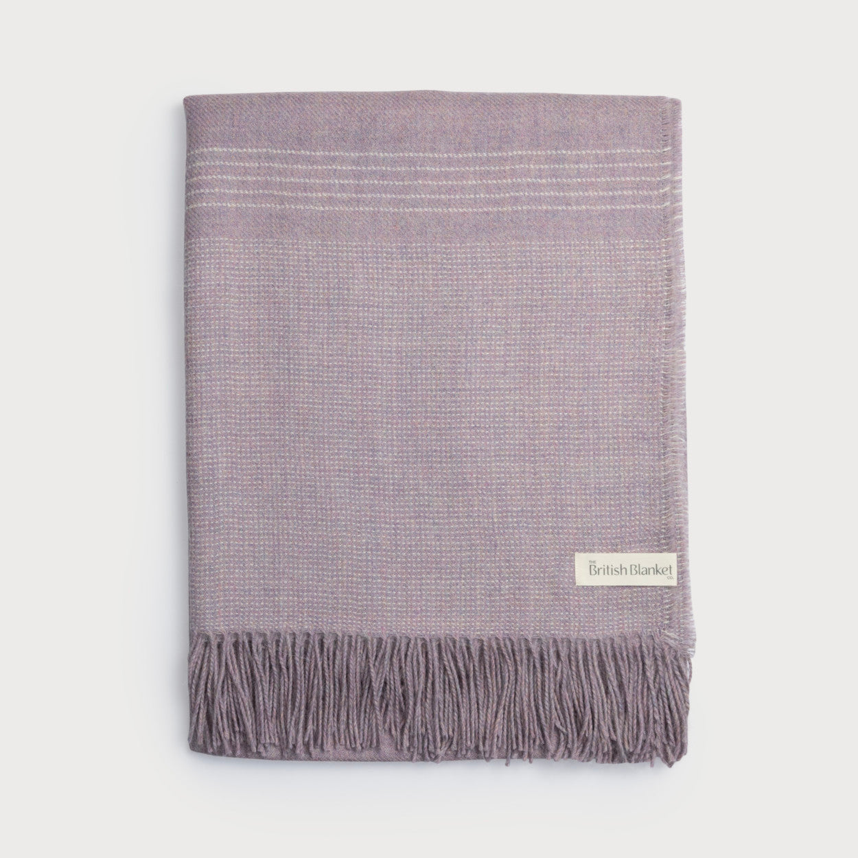 Alpaca Blanket Gift Box: Heather Pink with a lavender throw blanket, fringed edge, British Blanket Co. label, amber jar candle, and sea salt chocolate.