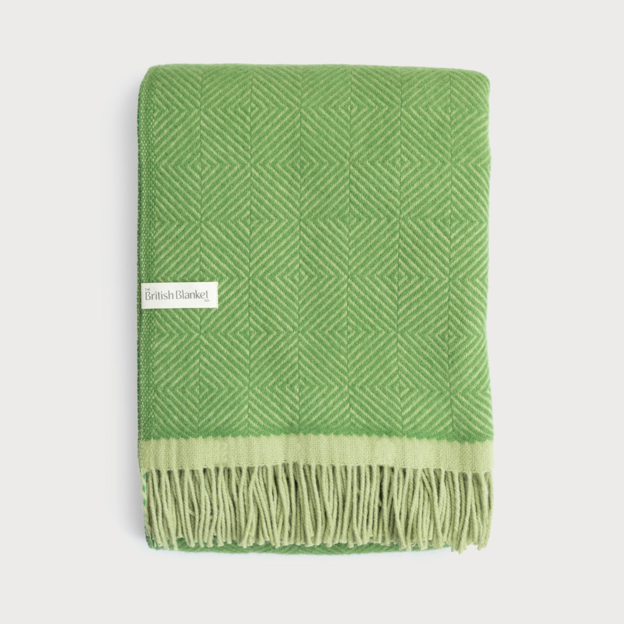 Wildweave Blanket Gift Box: Fennel & Catkin, features a folded green woven blanket with geometric patterns, fringe tassels, and a “The British Blanket Co.” label.
