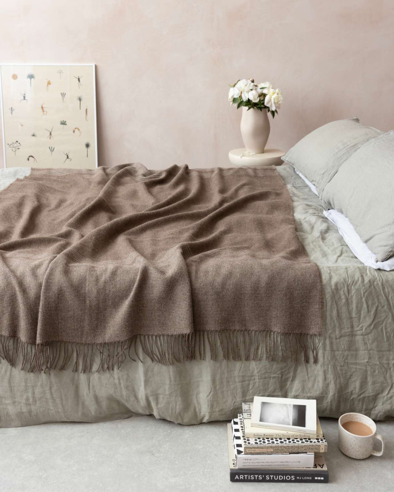 Alpaca Blanket Gift Box: Mocha Brown on bed with linen sheets, includes amber jar candle, sea salt chocolate, and message card in eco-friendly box.