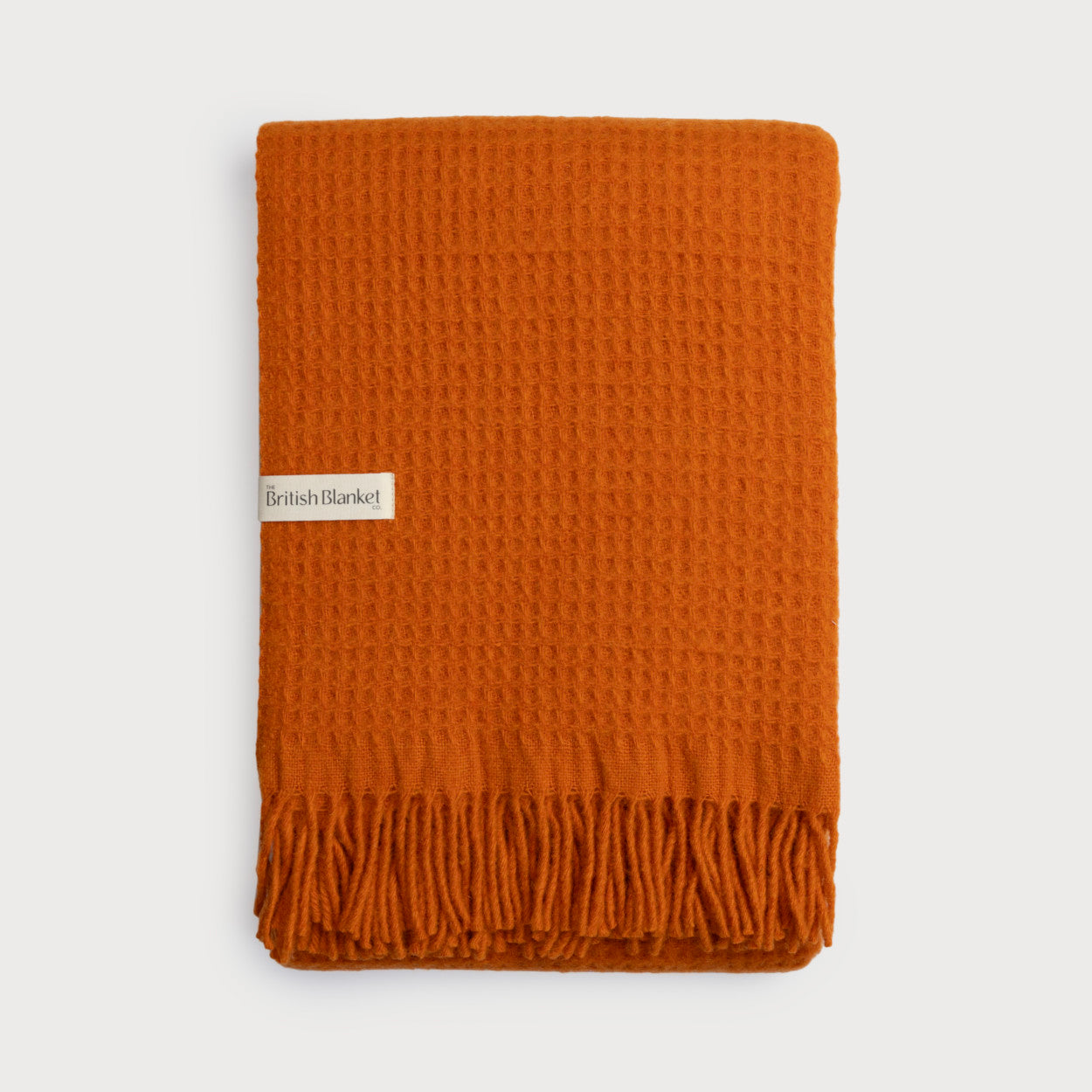 Bright Friday Blanket Bundle: Beacon, featuring a folded waffle-weave throw with fringe and a “British Blanket Co.” label, showcases comfort and quality.