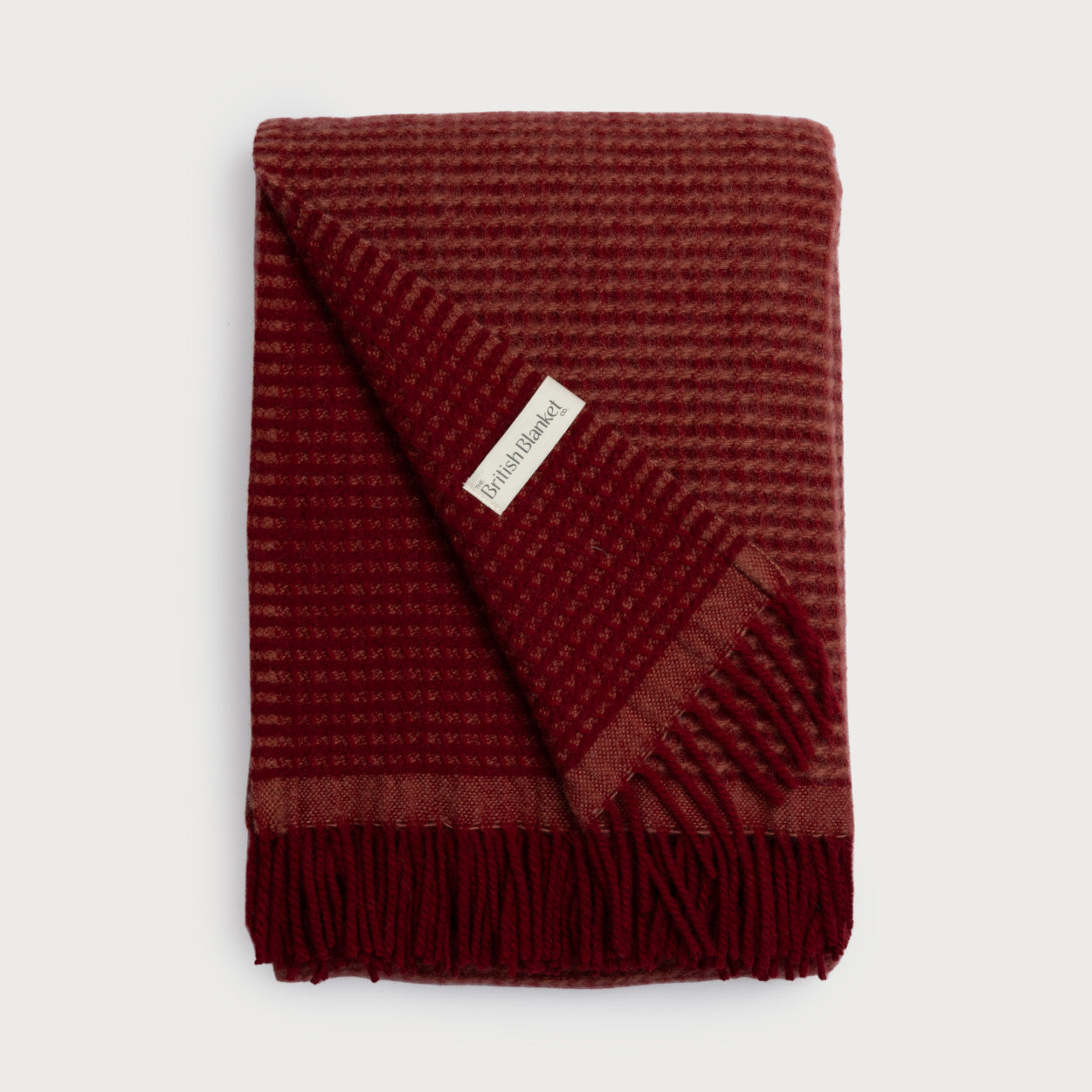 Totterdown Waffle Blanket: Air Balloon & Brunswick - red wool blanket with fringe and a white label, showcasing a textured, reversible waffle weave.