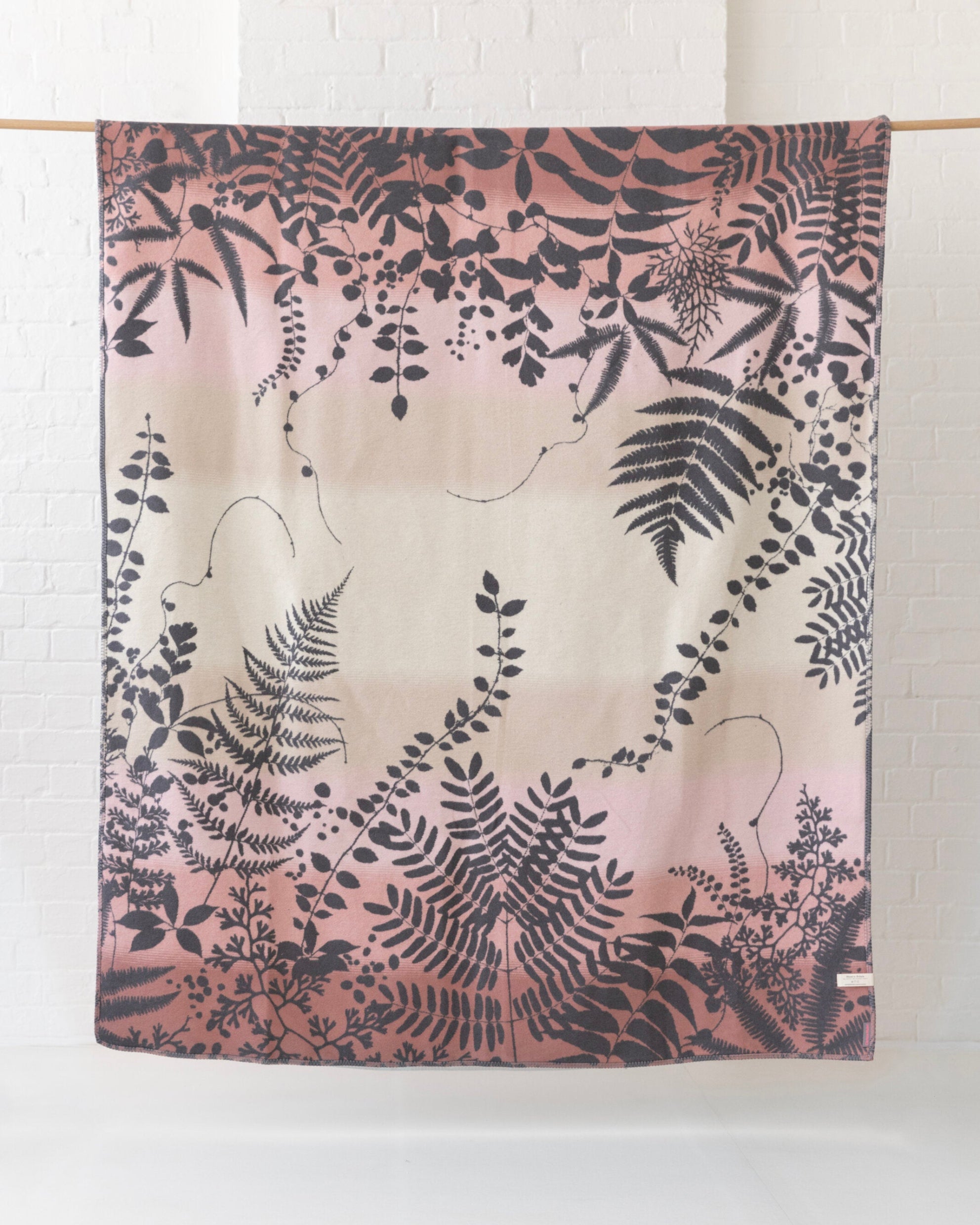 Clarissa Hulse Blanket: Kaleidoscope in Shell, featuring ombré cream to dusty pink hues with silhouetted fern and vine designs, jacquard-woven from recycled cotton.