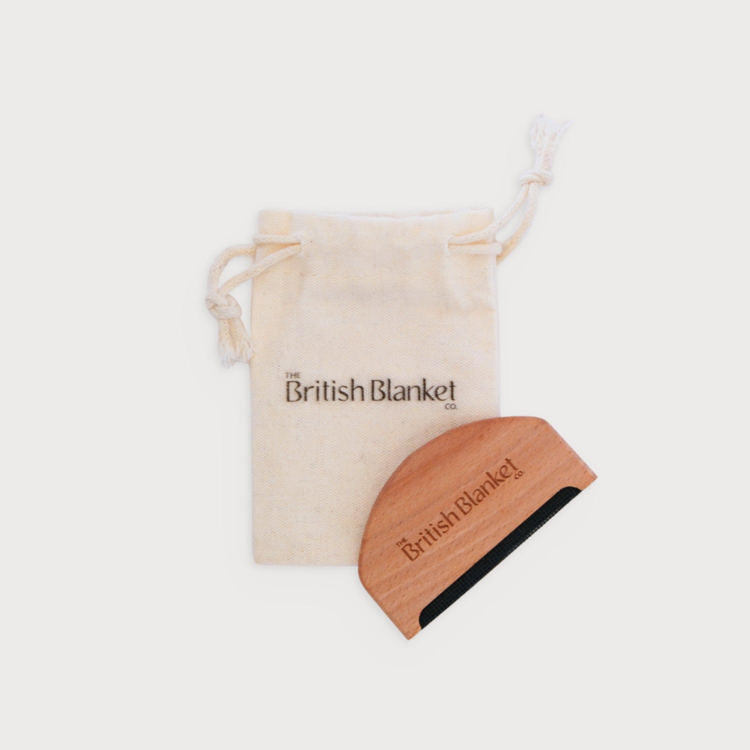 Wool Care Comb displayed with a beech wood handle, accompanied by a cotton storage bag, designed for gently removing pilling from woolen items.