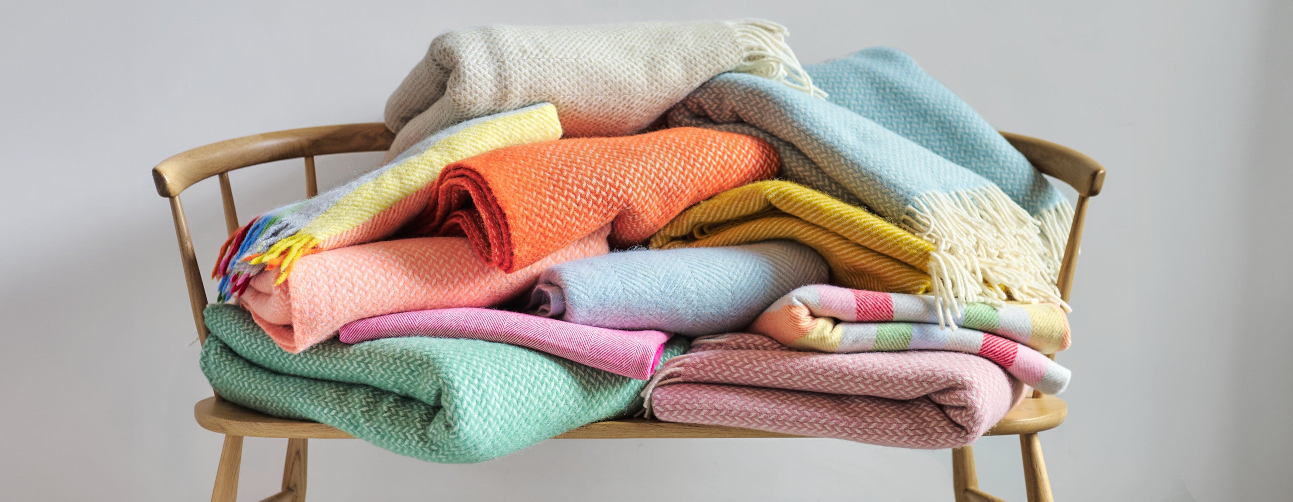 The British Blanket Company wool blankets in a stack on a wooden bench
