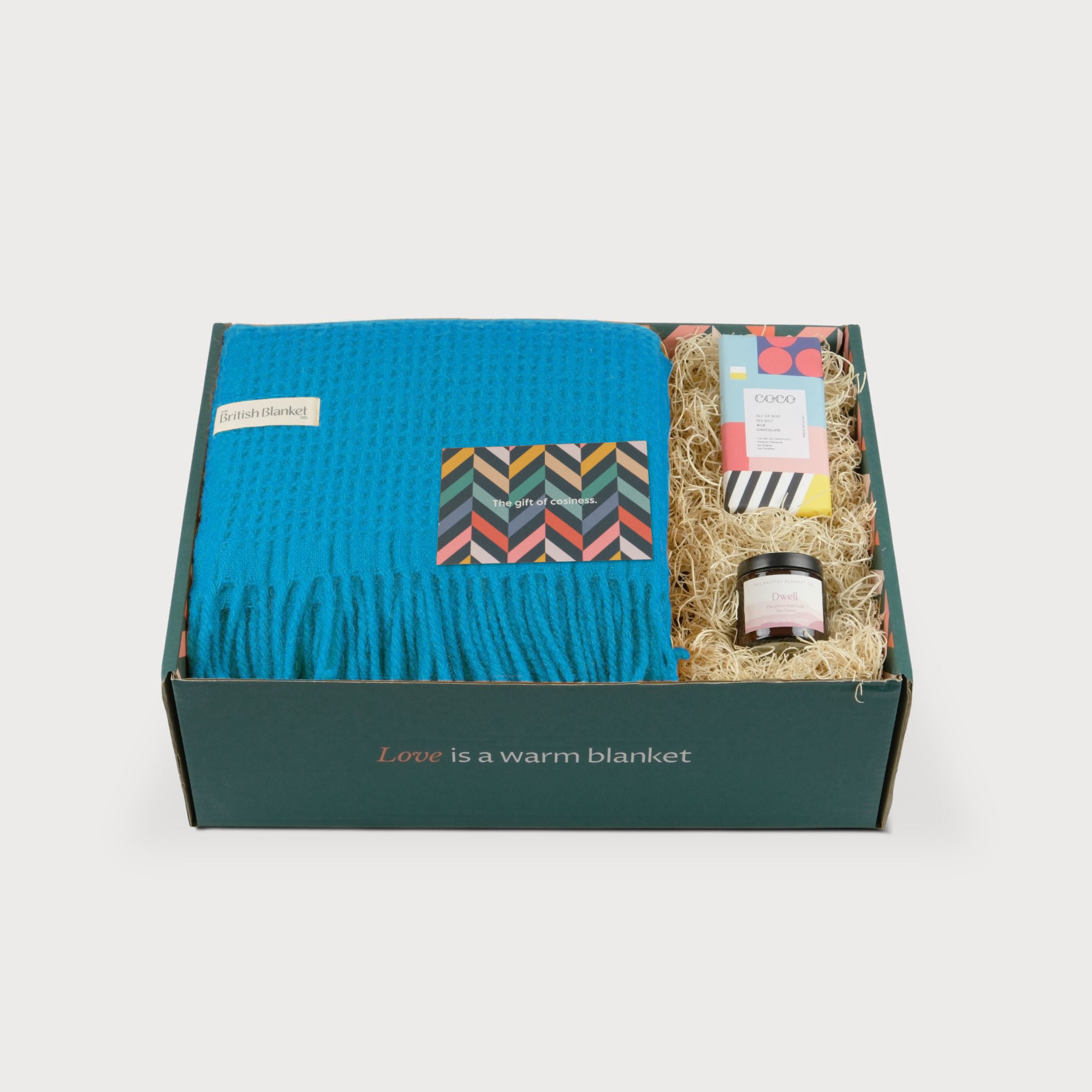 Totterdown Blanket Gift Box: Lido, featuring a waffle-knit throw, greeting card, COCO chocolate, and Dwell spread, all in a dark green gift box.