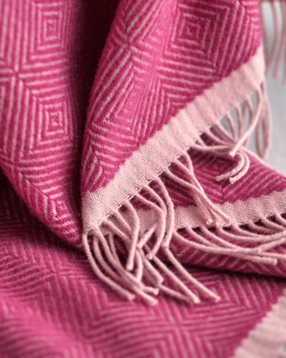 Wildweave Blanket Gift Box: Clover & Briar Rose features a pink geometric-patterned wool throw with tassels, perfect for cozy gift hampers.