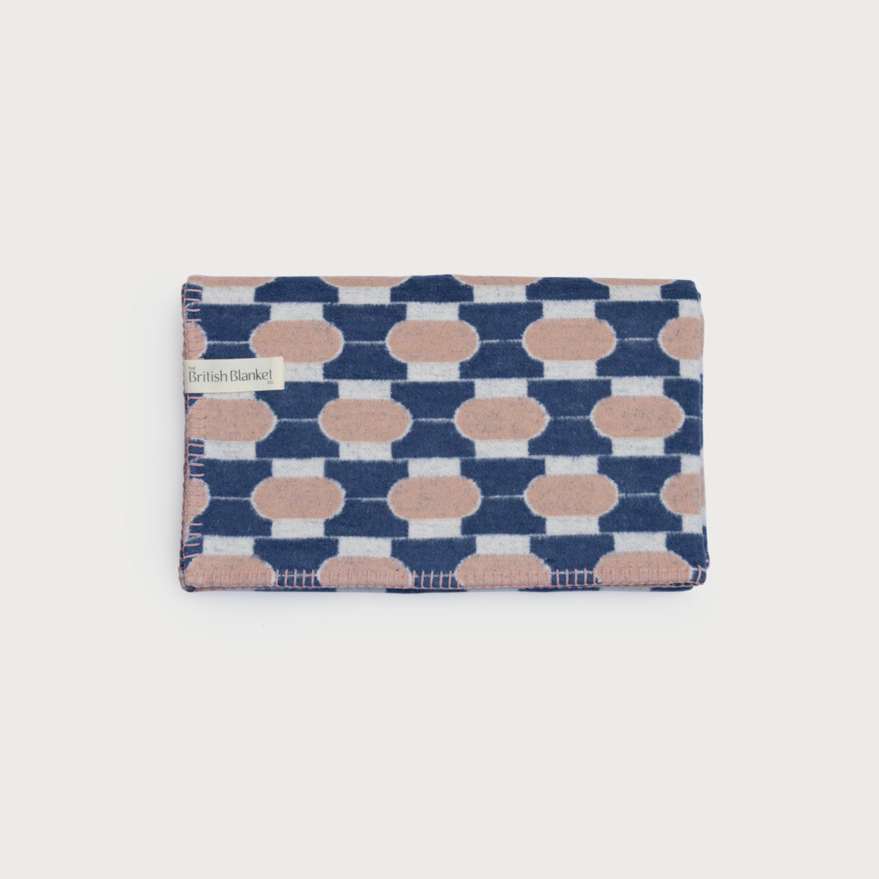Cloud Cotton Baby Blanket Gift Box: Boatyard Glow features a neatly folded wool blanket with a geometric pattern of rounded shapes against navy and off-white bands.
