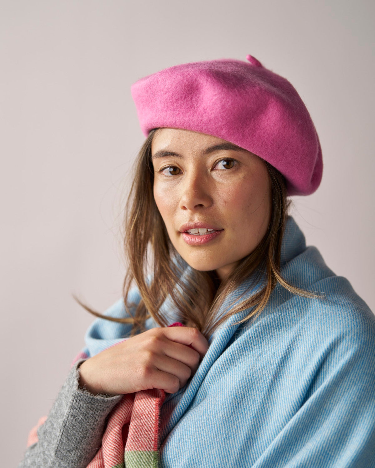 Woman wearing the Wool Beret Hat: Pink, showcasing its snug fit and hand-finished wool texture.