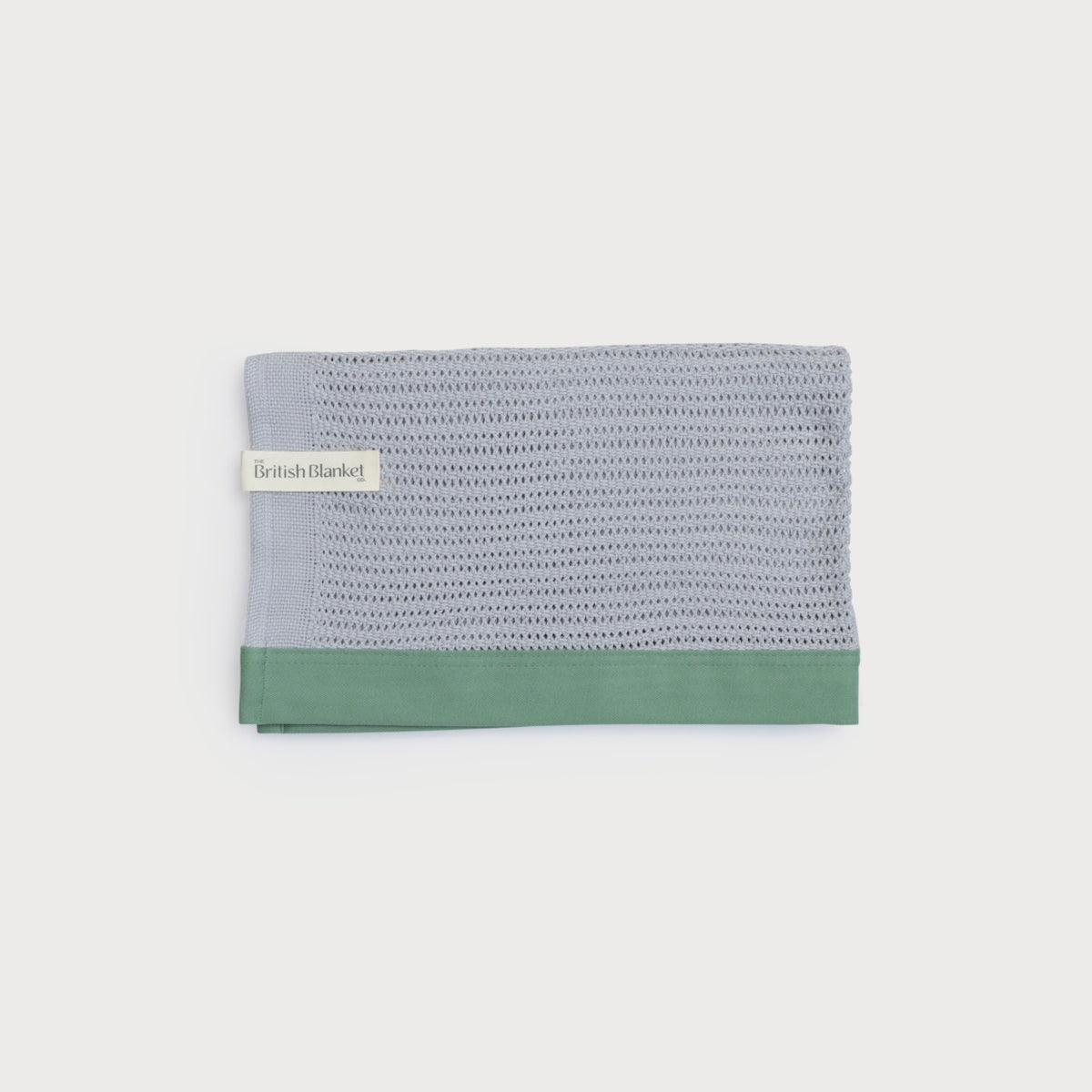 Organic Cellular Baby Blanket: Green, close-up of breathable, lightweight knitted fabric with contemporary cotton trim, showcasing craftsmanship from a traditional British mill.