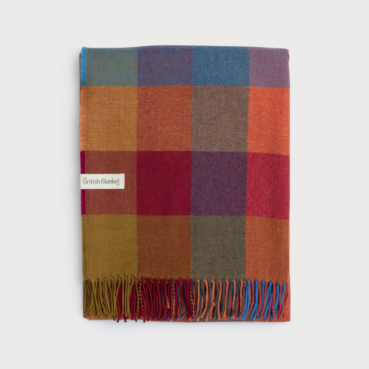 Merino Check Blanket: Multicolour, featuring a vibrant plaid pattern with fringe, woven from soft merino lambswool for a lightweight yet warm feel.