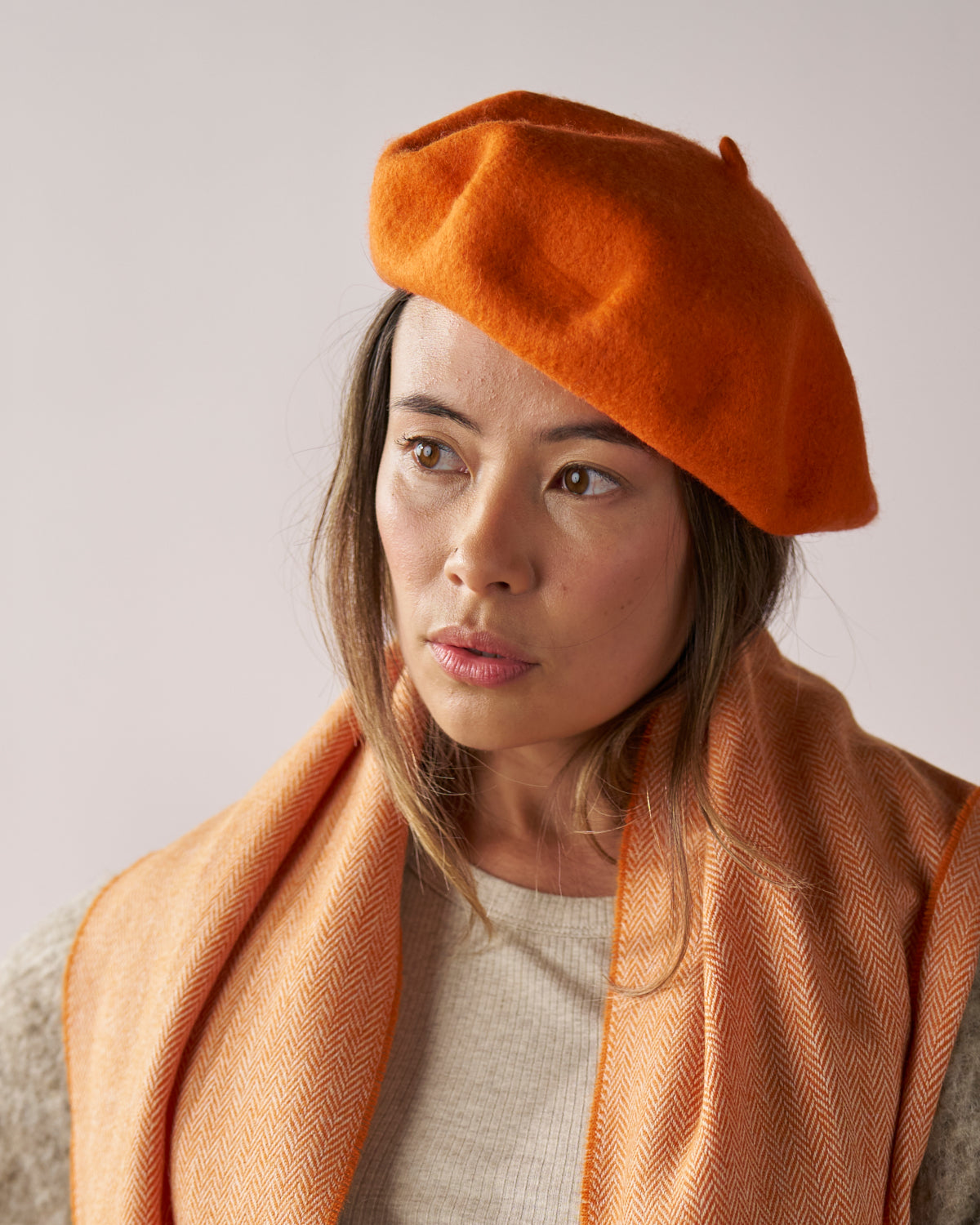 Woman wearing the Cosy Gift Set: Beret & Scarf, featuring a stylish beret and herringbone scarf, perfect for gifting in an eco-friendly box.