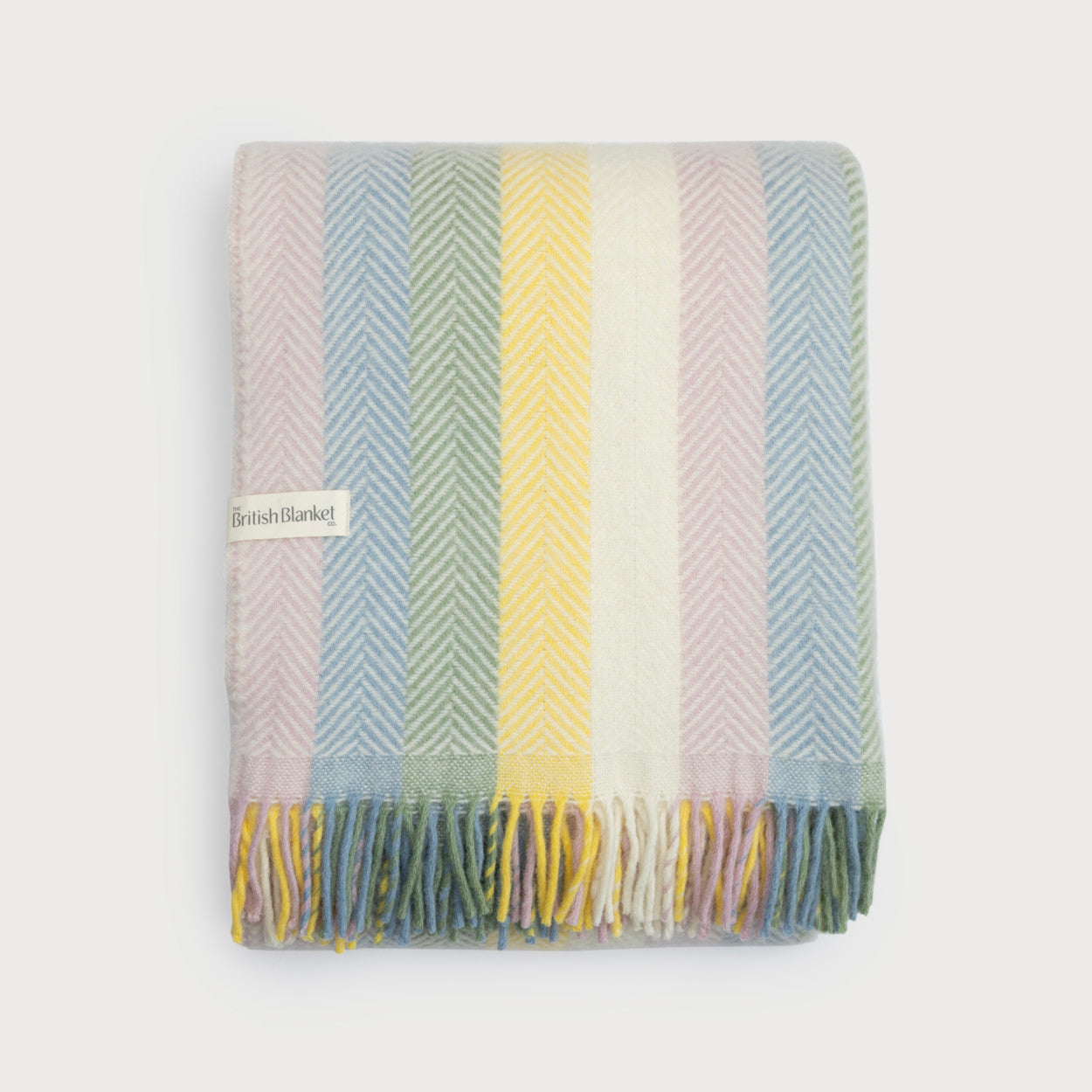 Rainbow Stripe Blanket Gift Box: Pastel includes a folded wool blanket with herringbone weave, fringed edge, and The British Blanket Co. tag, perfect for gifting.