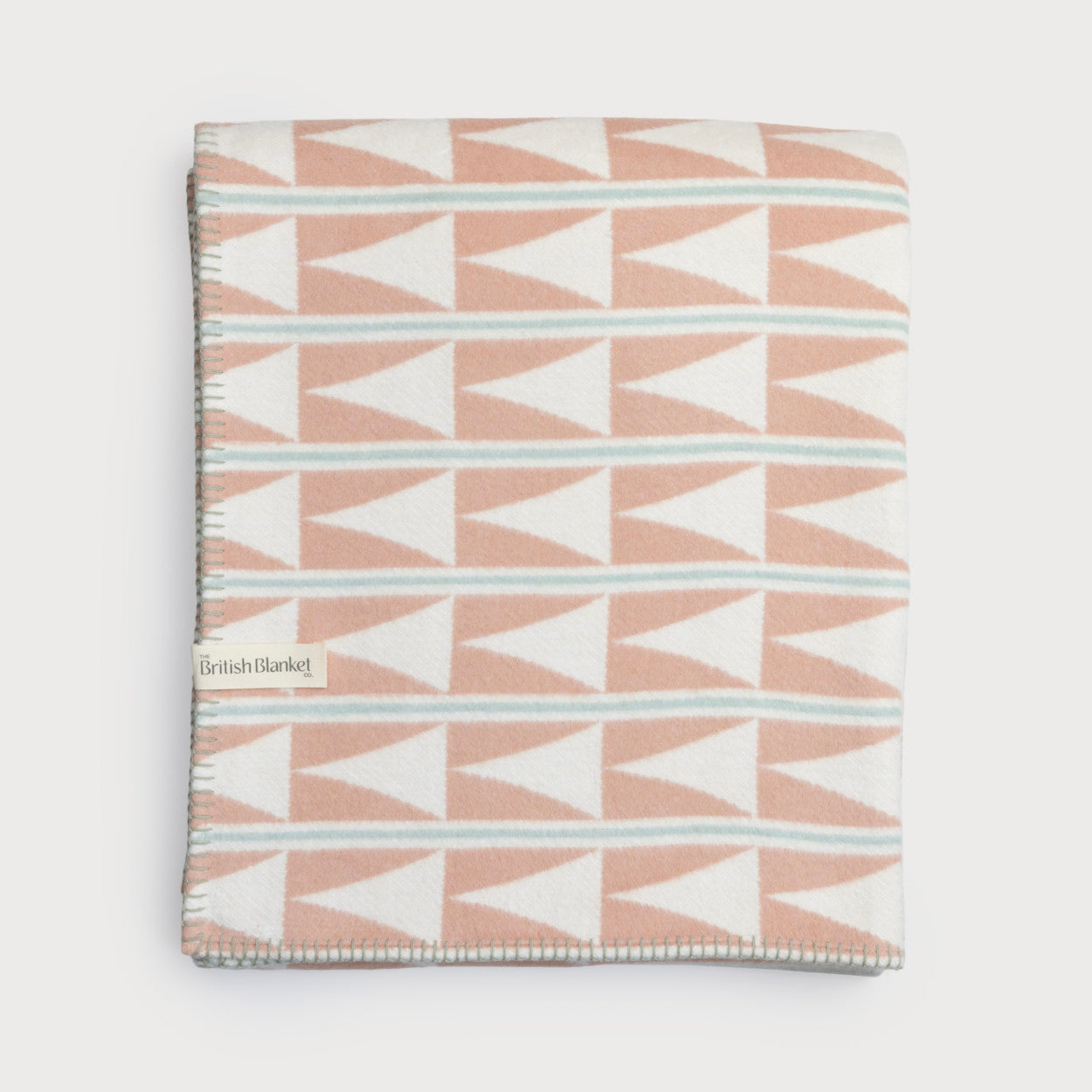 Cloud Cotton Blanket: Harmony Blossom with a geometric pattern featuring triangles, woven from recycled brushed cotton with a blanket-stitched edge.