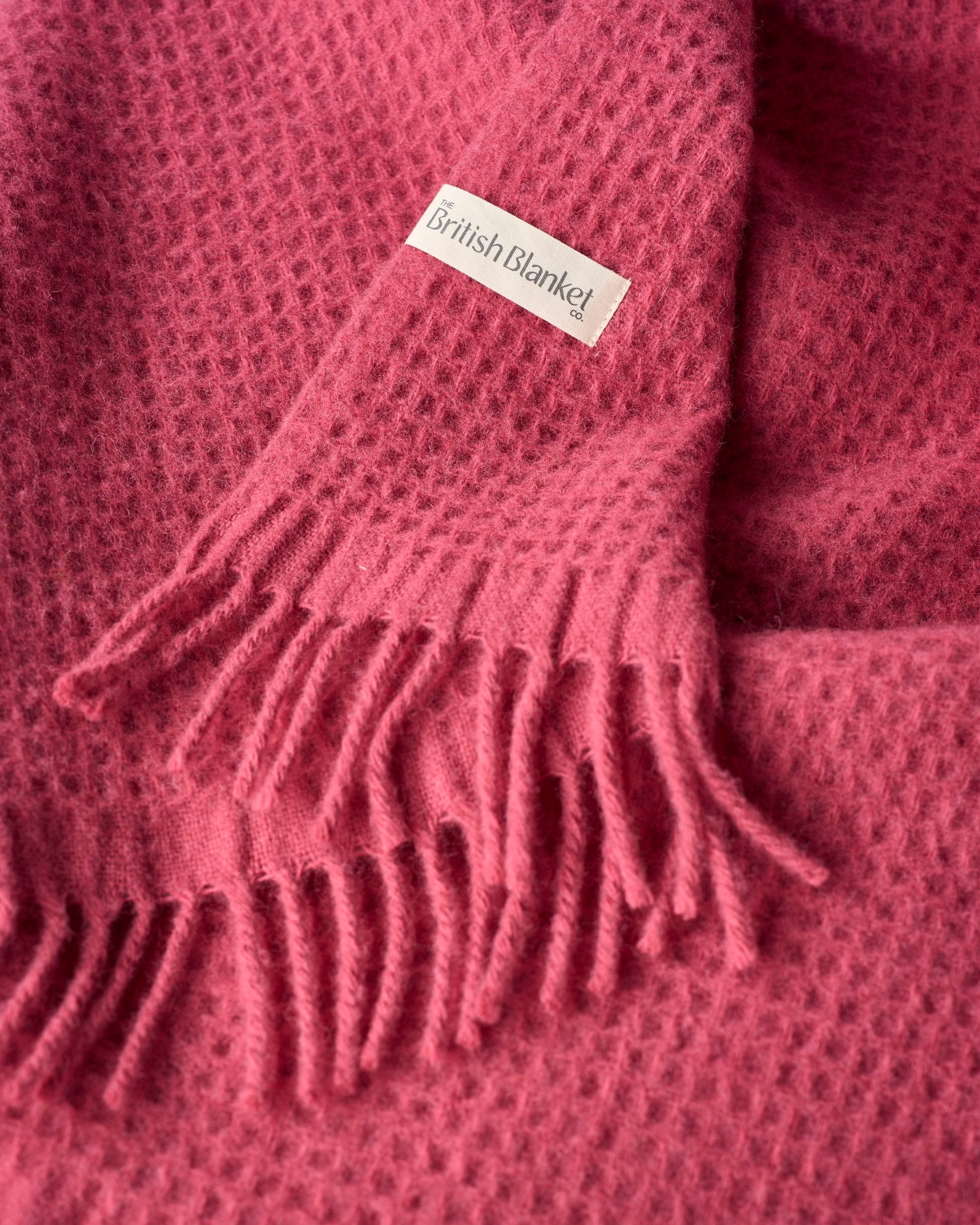 Close-up of the Bright Friday Blanket Bundle: Lush, showcasing its waffle-weave texture, fringed edge, and “The British Blanket Co.” label.