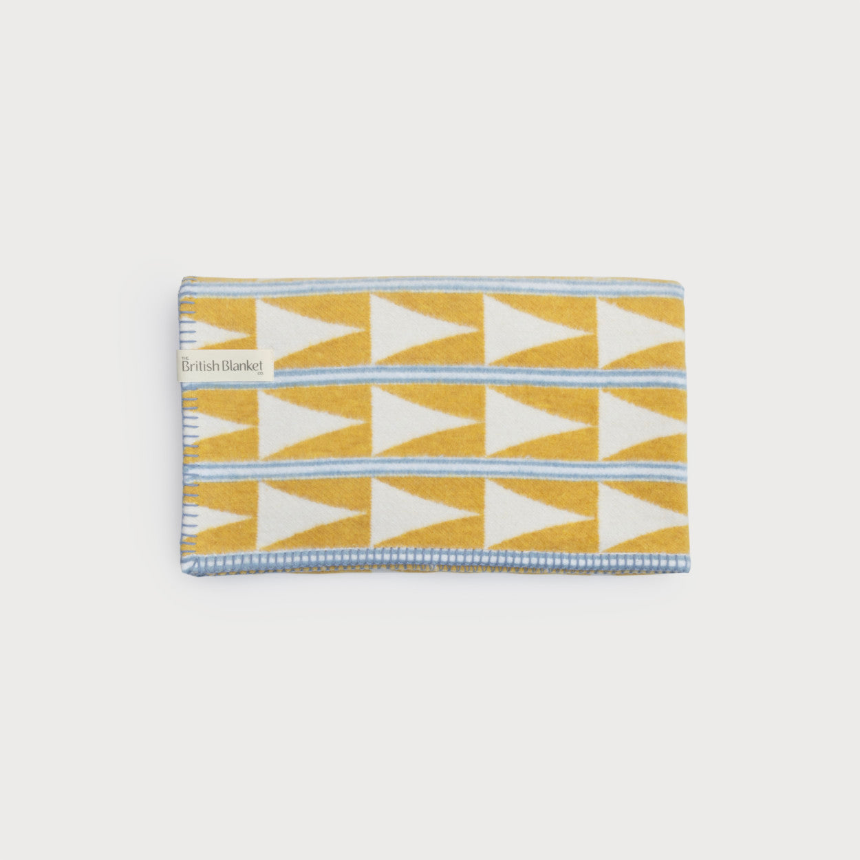 Cloud Cotton Baby Blanket: Harmony Lemonade features a geometric pattern with white triangles and sky-blue stripes on mustard-yellow, finished with a matching blanket-stitch edge.
