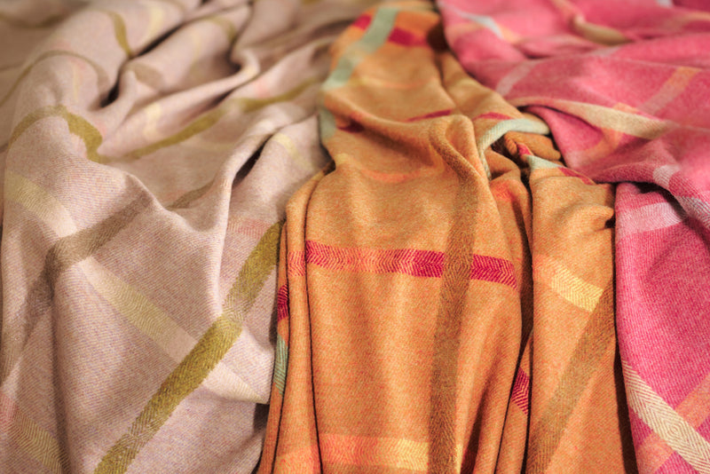 Three Garden Flowers lambswool blankets in brown, orange, and red