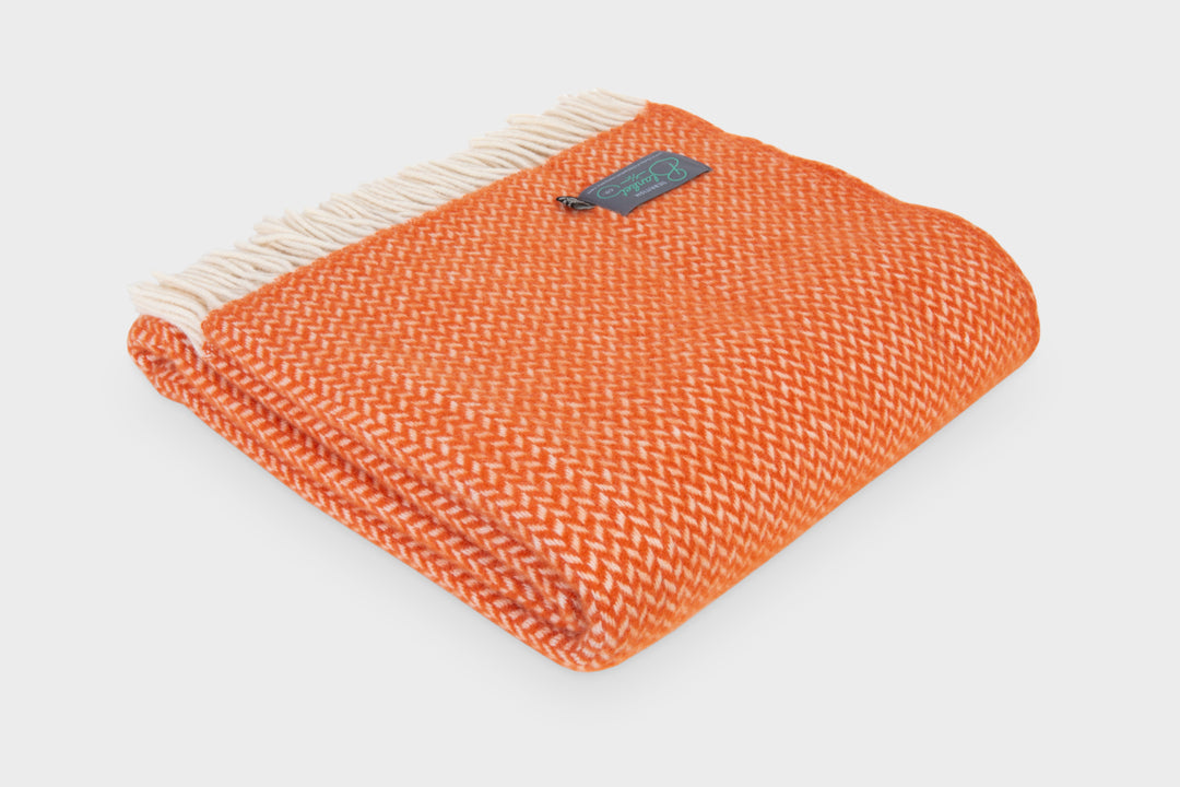Folded large orange herringbone wool throw by The British Blanket Company
