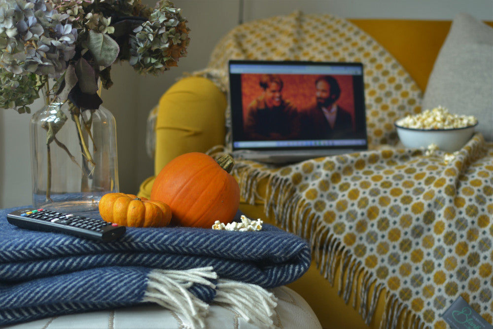 Laptop sits on top of a wool British made blanket with a movie playing for a cosy night 