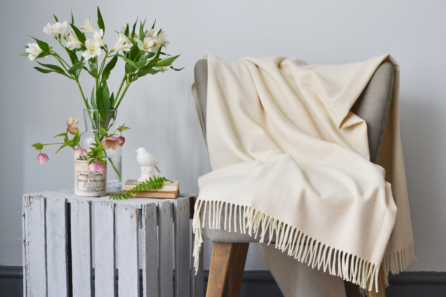 An XL wool blanket from The British Blanket Company is spread out across a beautiful chair 