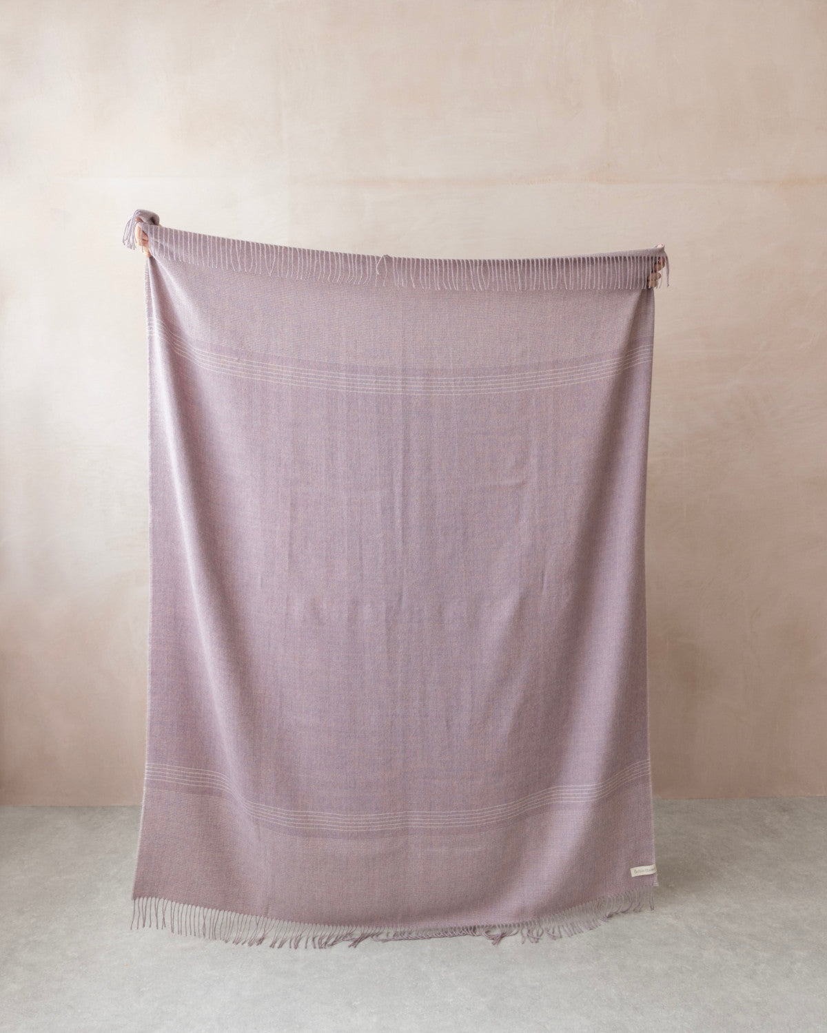 Alpaca Blanket Gift Box: Heather Pink features a soft-woven blanket with fringe, complemented by a candle and chocolate, perfect for gifting.