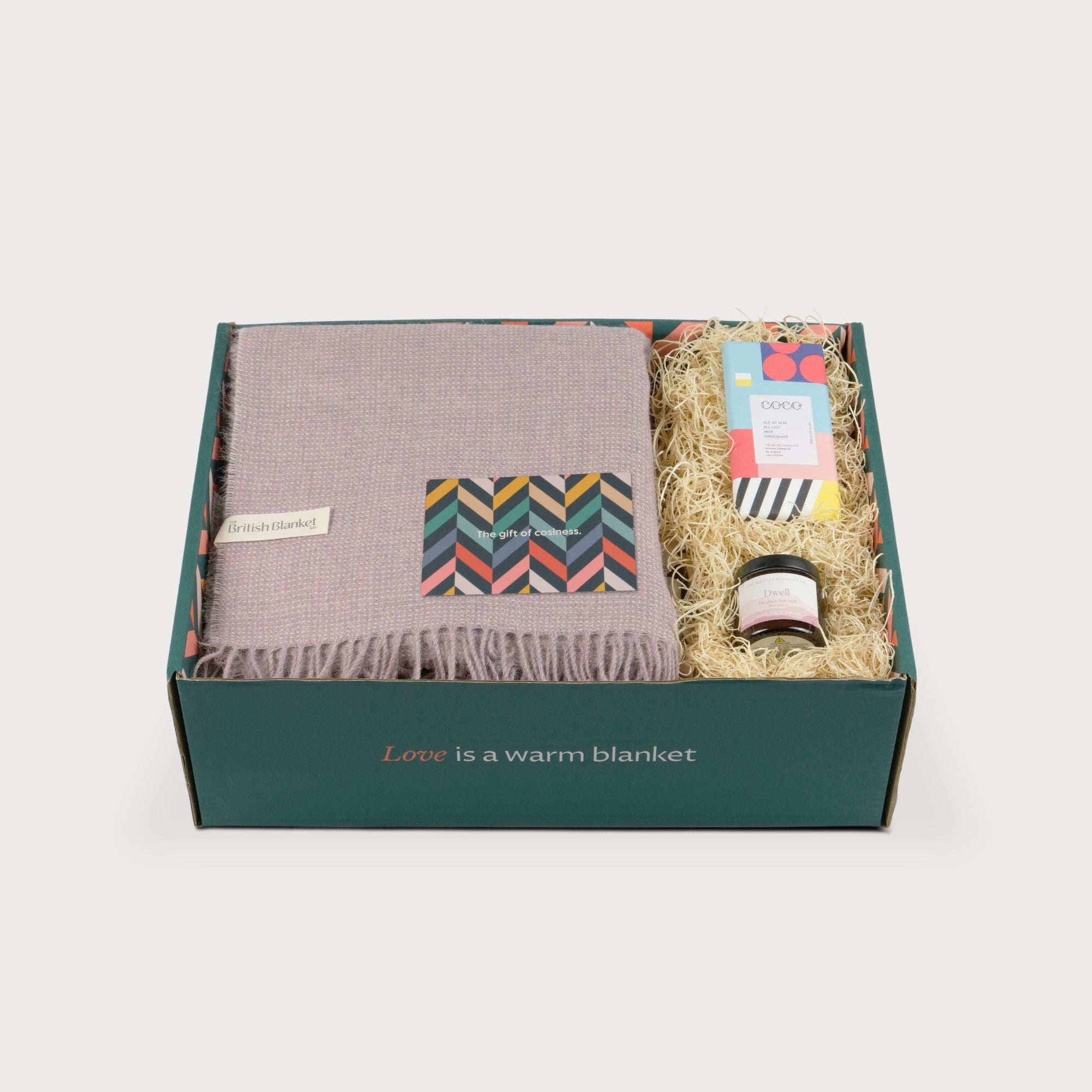 Alpaca Blanket Gift Box: Heather Pink featuring a British Blanket Co. blanket, COCO chocolate, amber jar candle, and greeting card in an eco-friendly green box.