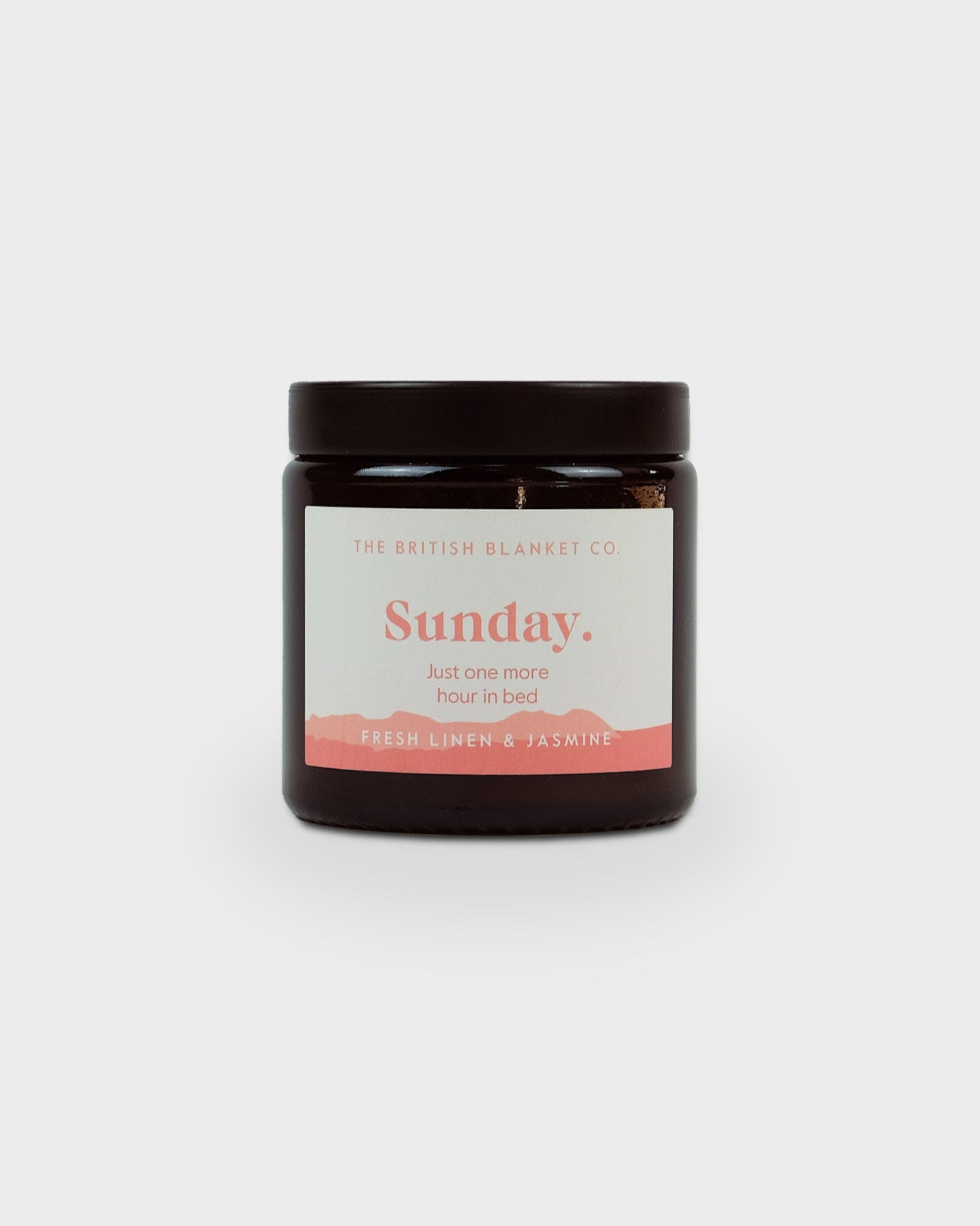 Cosy Gift Set: Happy Birthday featuring a dark glass jar candle labeled “Sunday. Just one more hour in bed” with Fresh Linen & Jasmine scent.