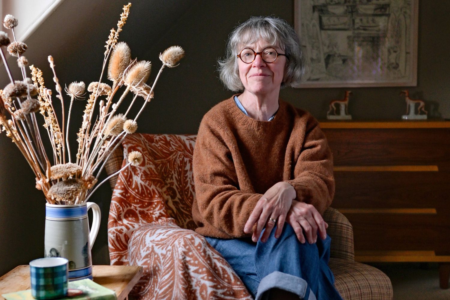 Angie Lewin in her Home in Scotland, with her special edition blanket, Forest Floor in Rust.