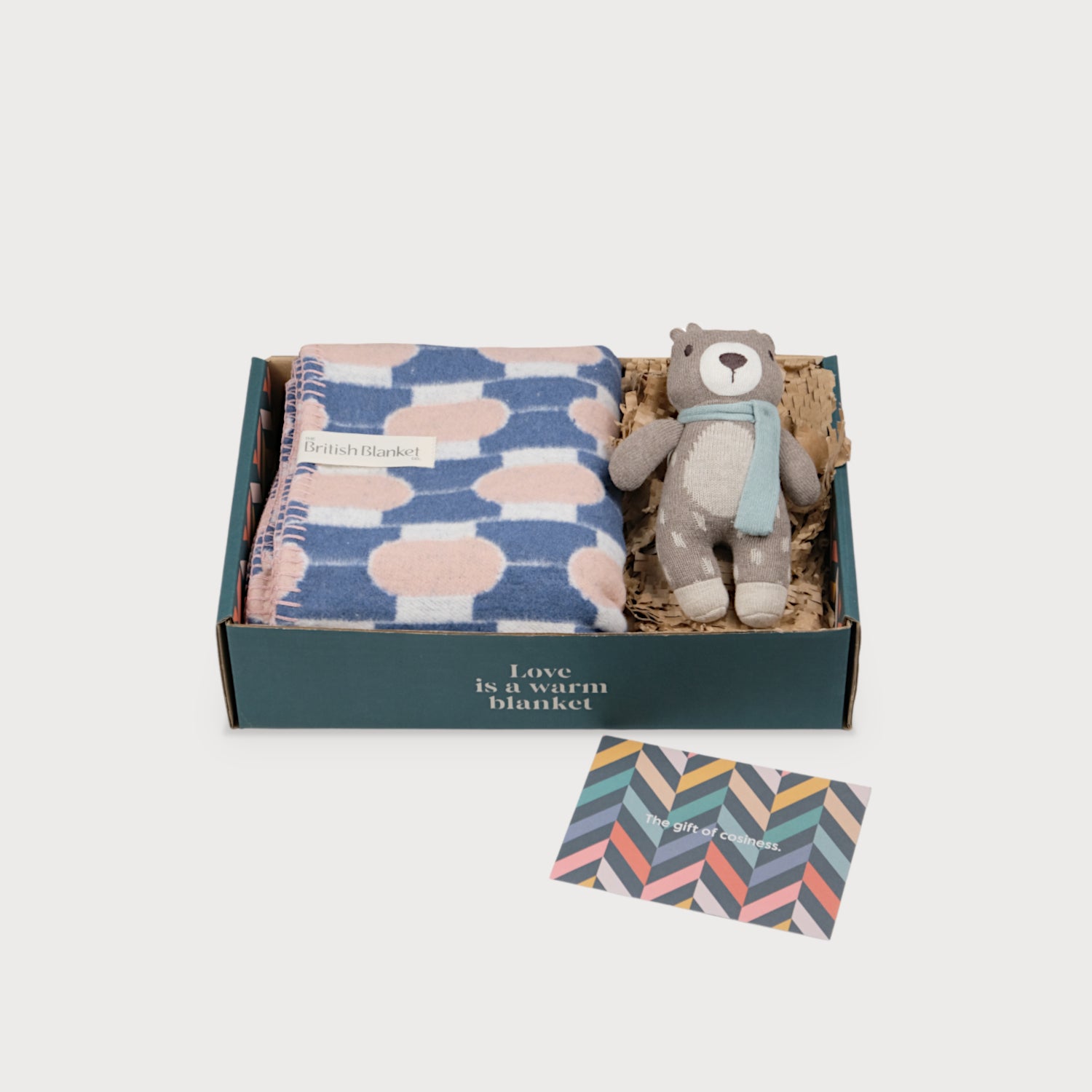 Cloud Cotton Baby Blanket Gift Box: Harmony Blossom includes a geometric wool blanket, a knitted teddy bear with a scarf, and a chevron designed gift card.
