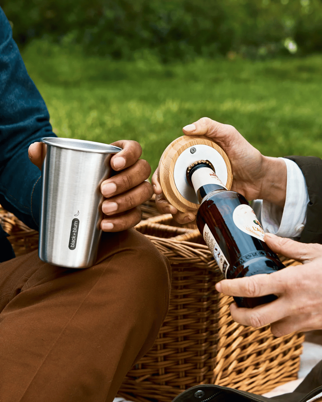 People using the wooden bottle opener with the Black + Blum Stainless Steel Tumblers