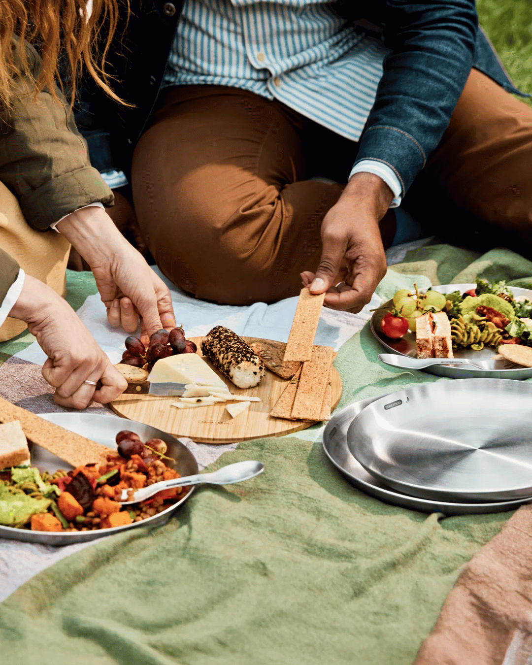 Group of friends sharing a cheese board on the Black + Blum plate and chopping board set