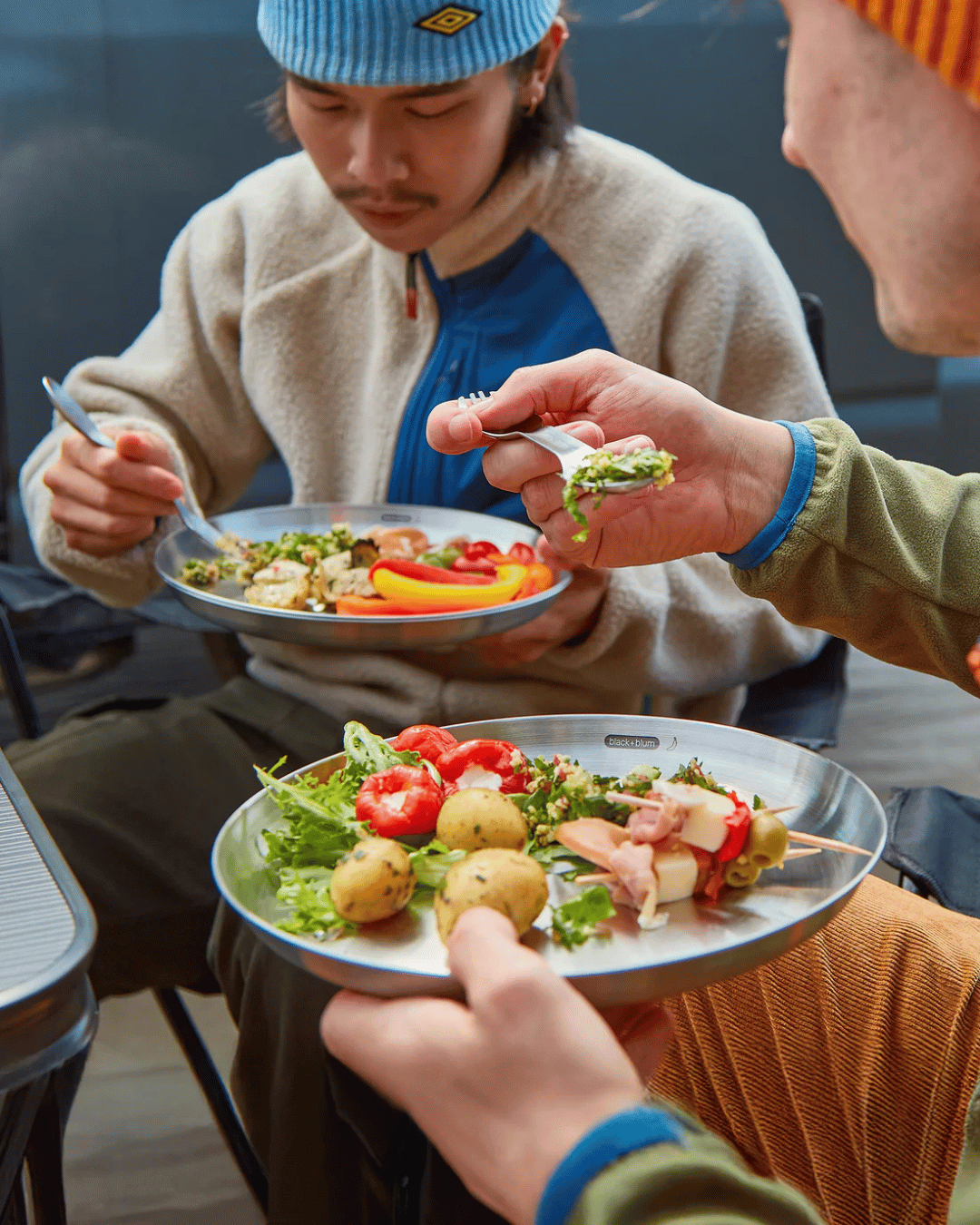 Friends having a meal with the Black + Blum Stainless Steel plate set