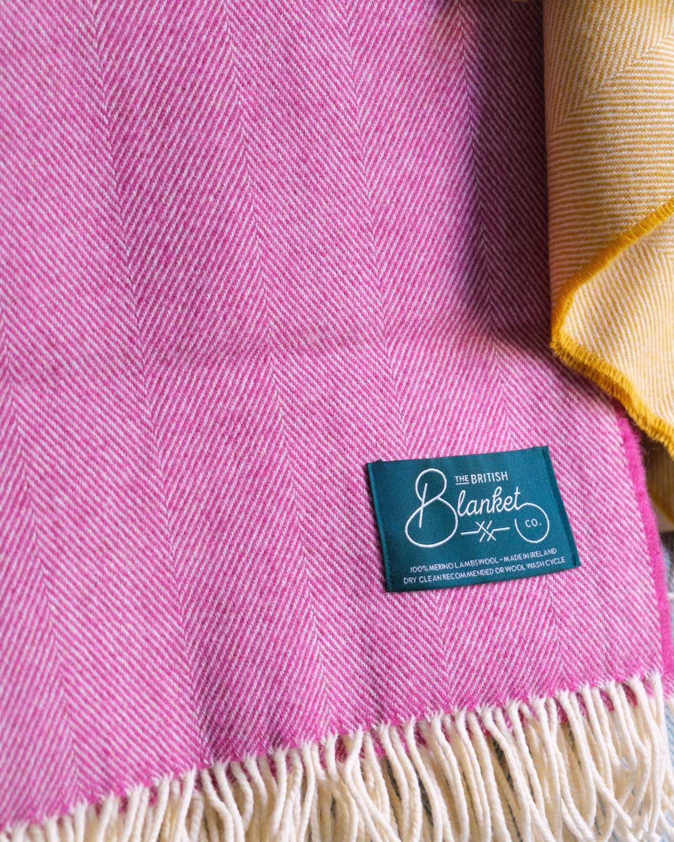 Pink merino wool throw on a from The British Blanket Company