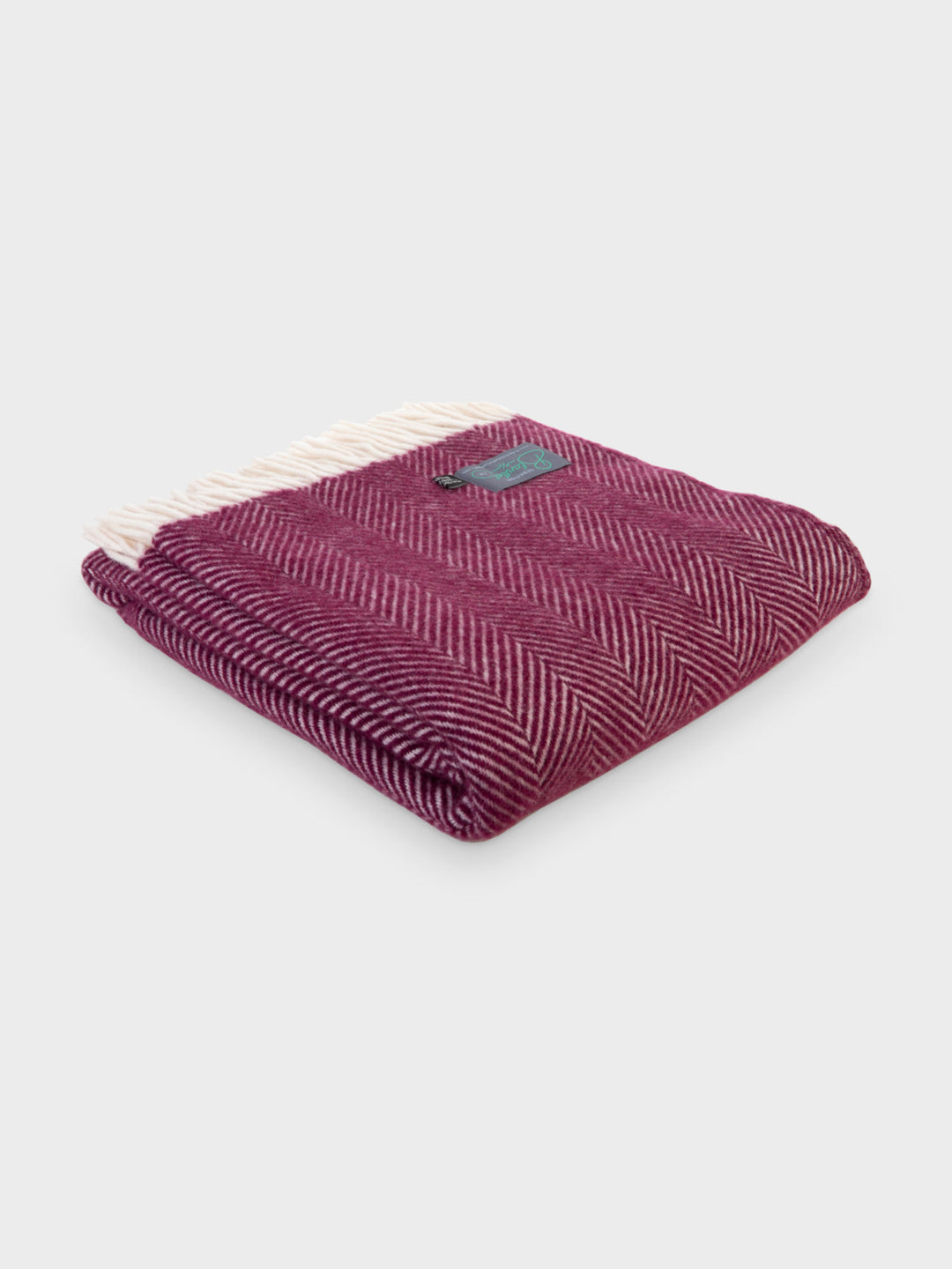 A folded burgundy herringbone wool throw by The British Blanket Company.