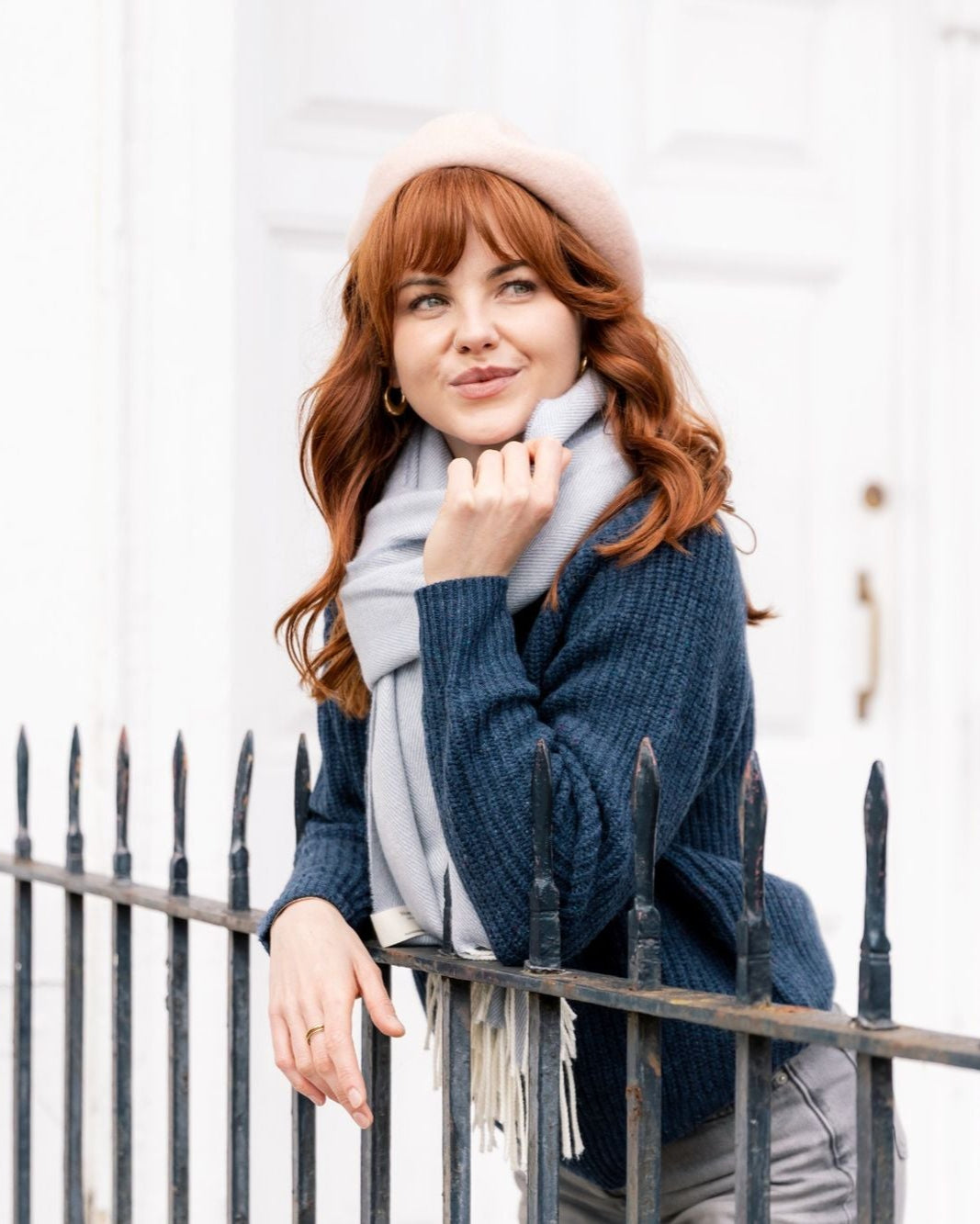 Woman in pink Wool Beret Hat: Baby Pink, showcasing its premium thickness and chic style, paired with a blue knit sweater and gray scarf.