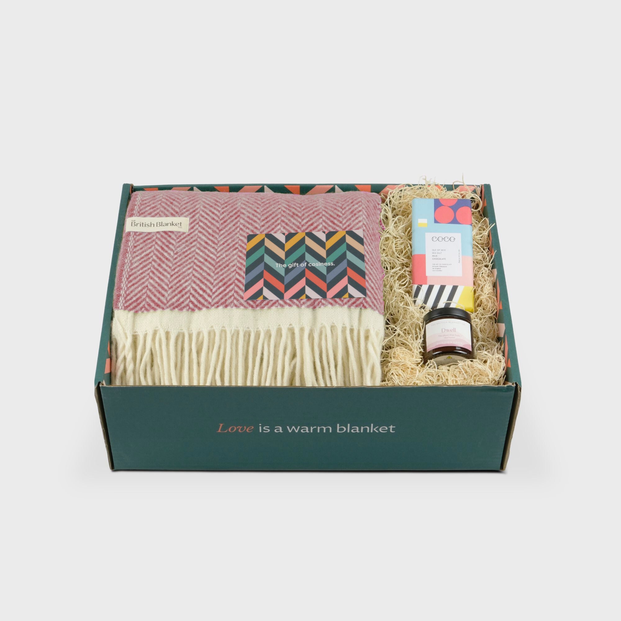 Clifton Blanket Gift Box: Rose features a pink herringbone wool blanket, spread jar, chocolate bar, greeting card, all in a green box with cozy message.