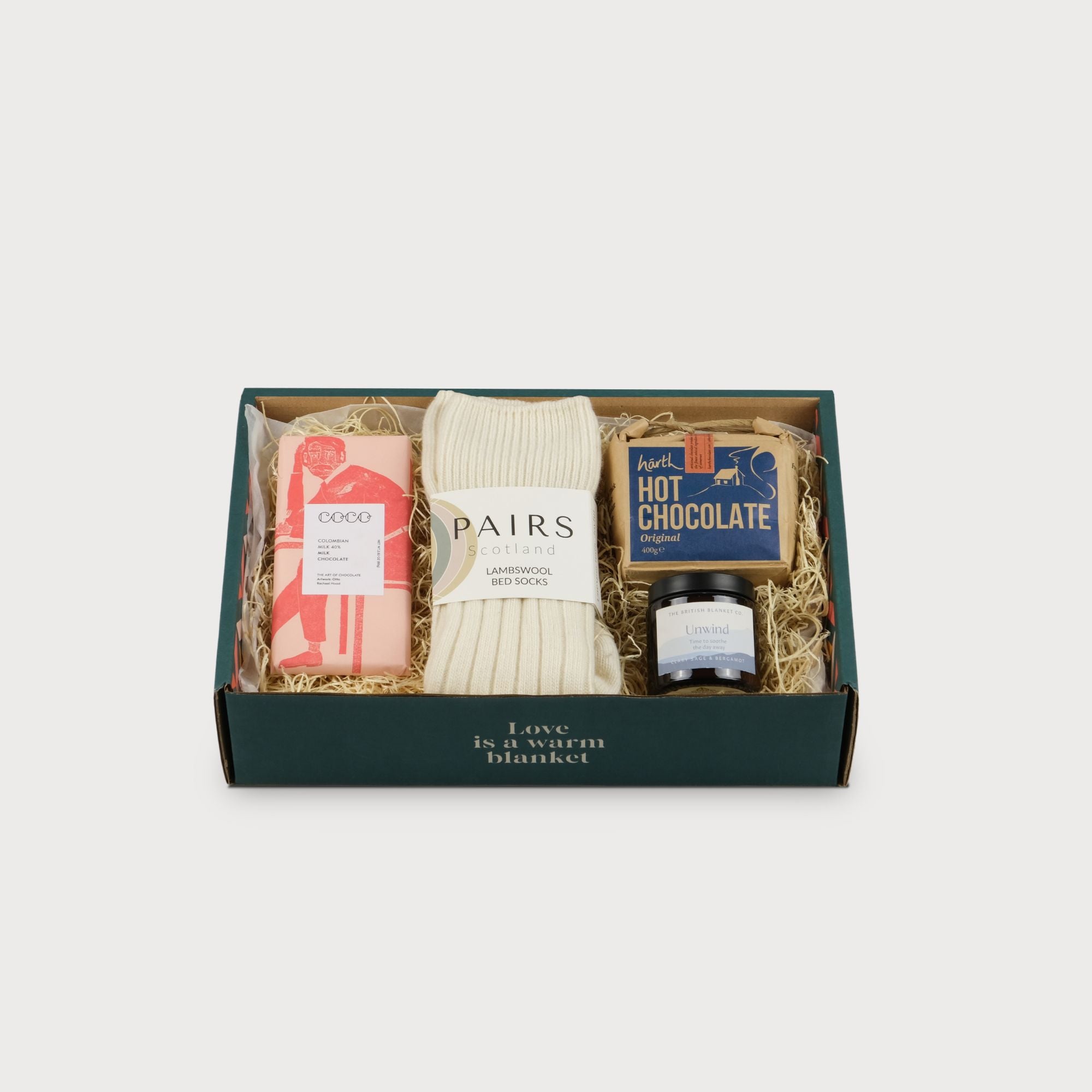 Cosy Gift Set: Chocoholic featuring a jar labeled artisan hot chocolate, Coco Chocolatier's Colombian Milk bar, and a small eco-friendly gift box.