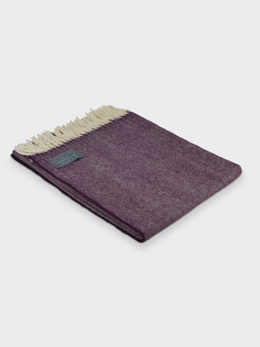 Folded purple herringbone wool throw by The British Blanket Company.