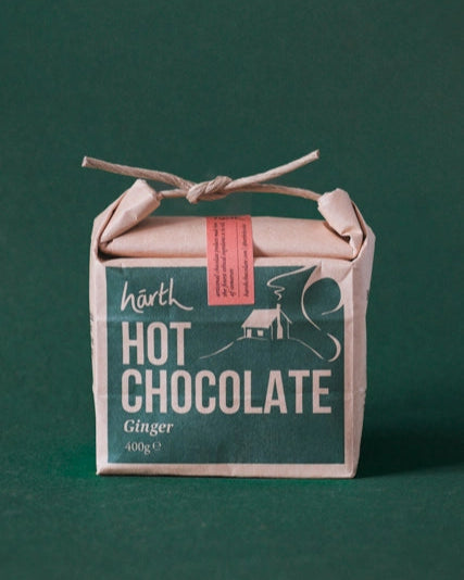 Artisan Hot Chocolate in brown paper, tied with twine, labeled “Ginger • 400 g”, perfect for creating a luxurious, velvety drink experience.