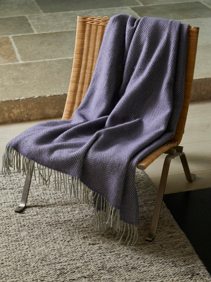 Rattan chair with Lavender Purple and Grey Herringbone Throw by The British Blanket Company